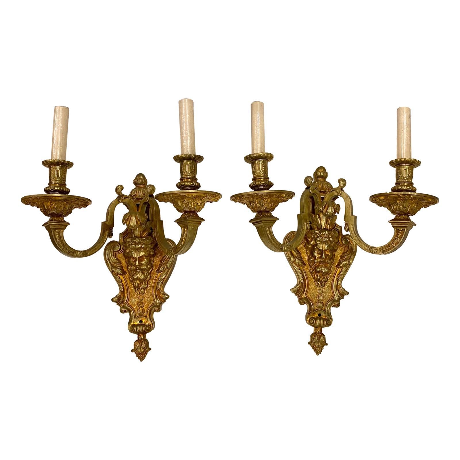 Pair of circa 1920s French gilt bronze sconces with mask details.

Measurements:
Height: 14