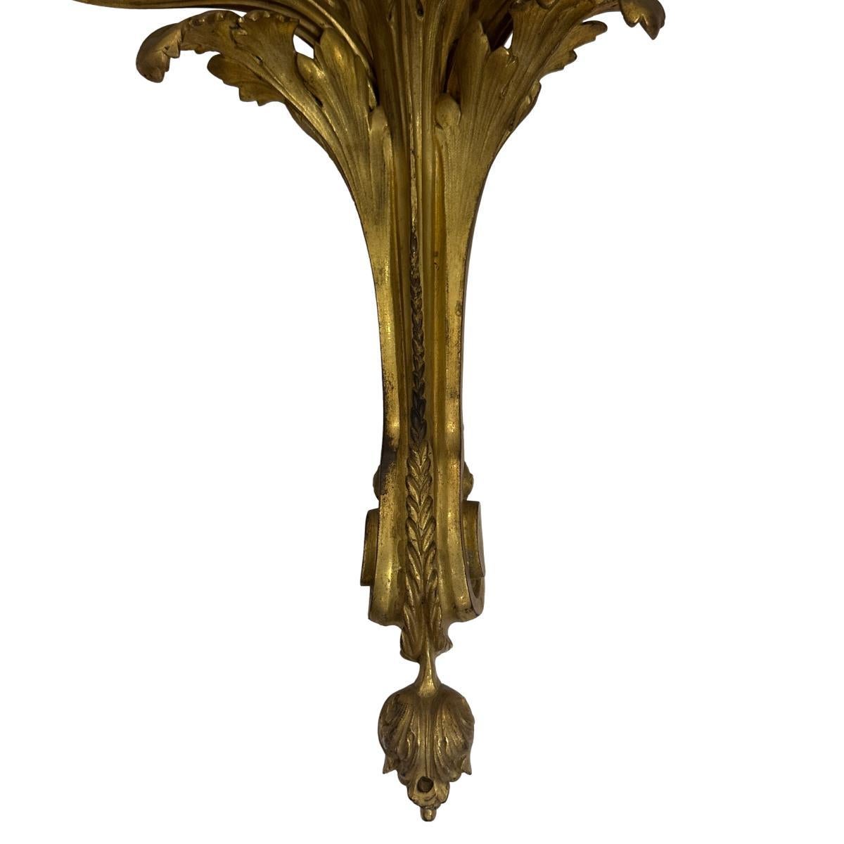 Coppia di appliques a tre bracci in bronzo dorato francese del 1920 circa.

Misure:
Altezza: 17,5
Larghezza: 15
Profondità: 10