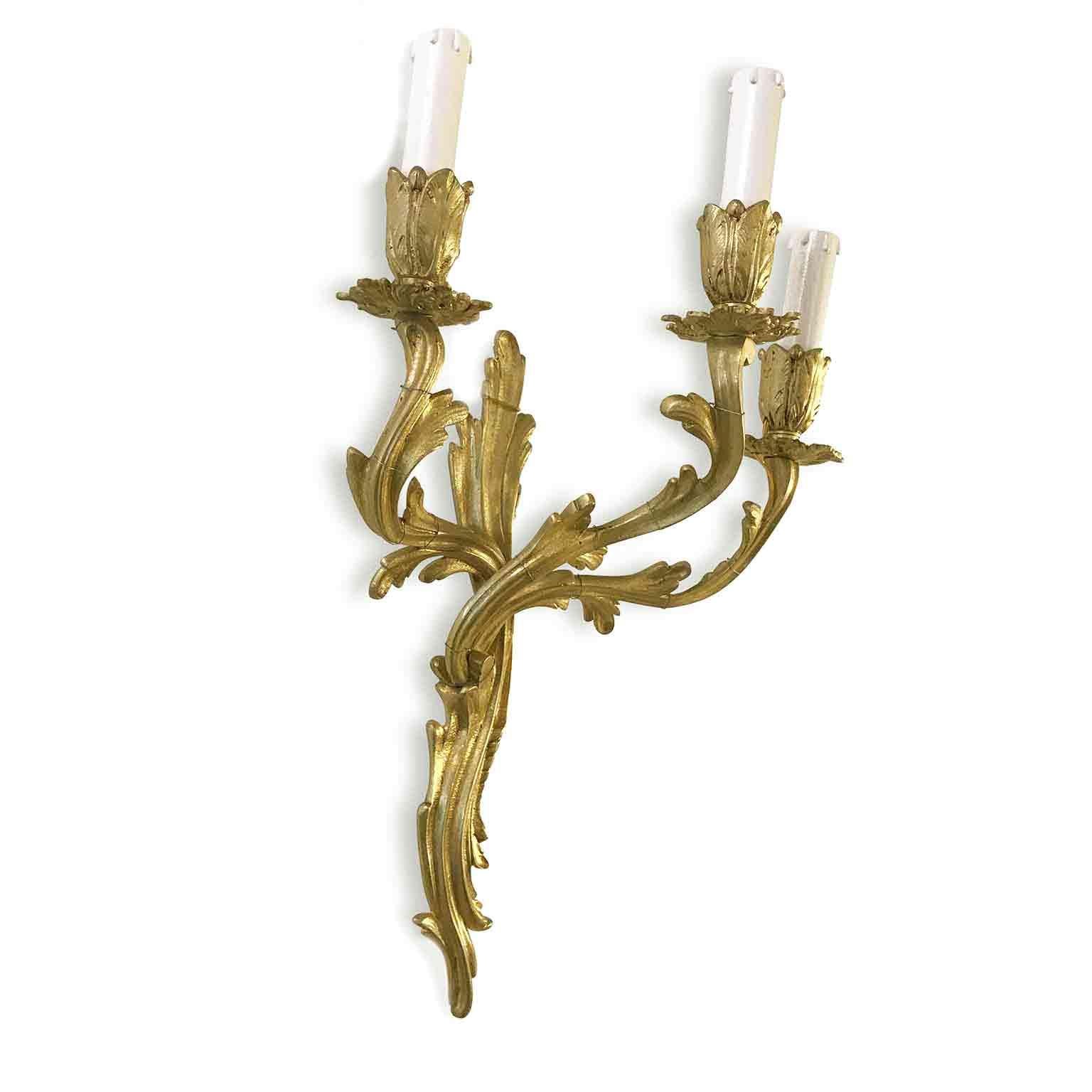 A pair of Louis XV style gilded bronze three-armed antique foliate wall lights sconces, of French origin, dating back to first half of 1900.
Acanthus leaf scrolling arms with leaf bobeche drip pans and bulbous candle sconces, original and beautiful