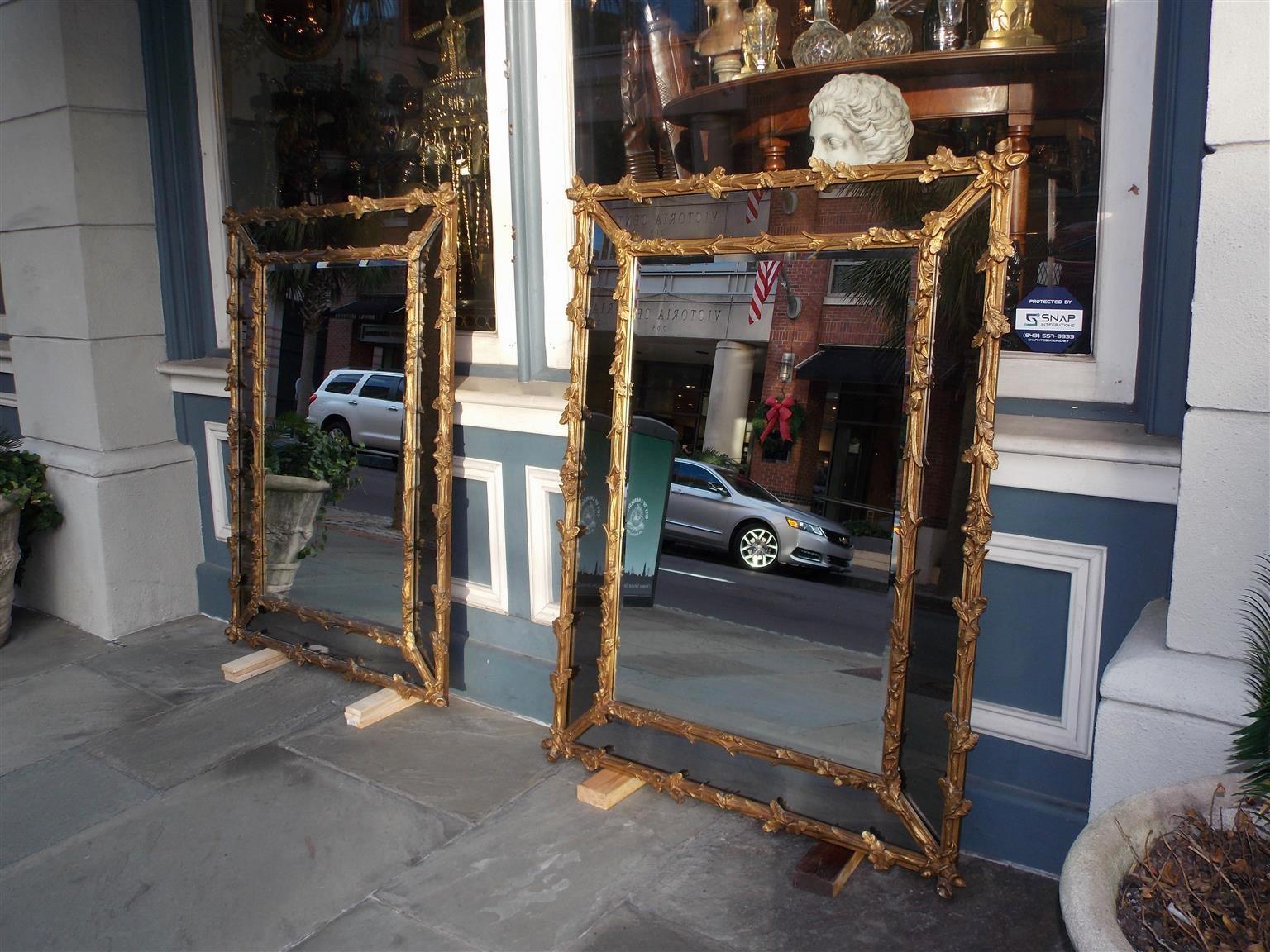 Pair of French gilt carved wood foliage and acorn motif wall mirrors. Mirrors retain the original beveled glass and wood backs covered with paper, Mid-19th century.