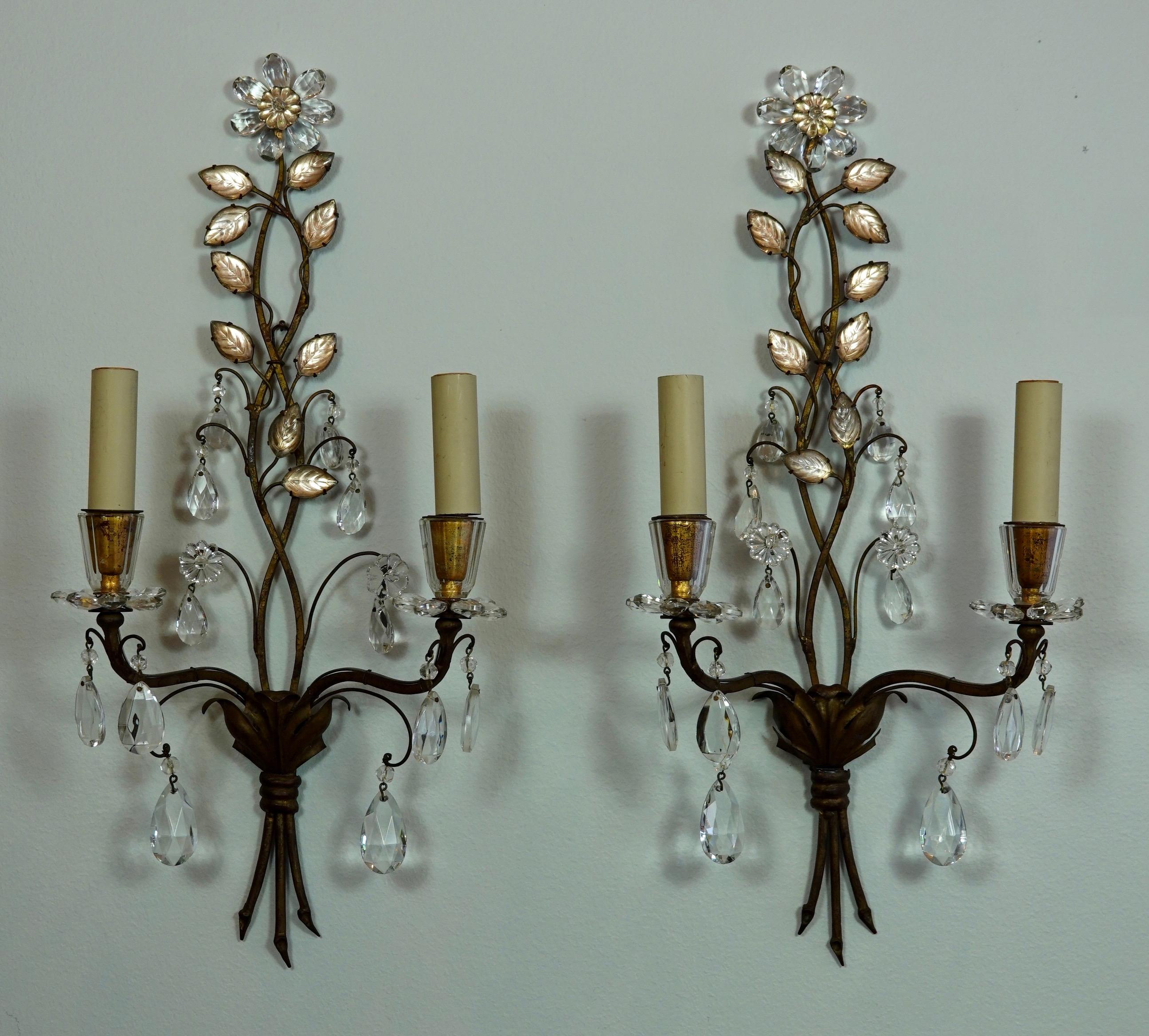 Pair of very elegant French gilded metal and tole sconces with glass leaves and drops by Maison Baguès (midcentury). The bobesches are hand-strung crystals in the form of flowers. The pair of sconces have two lights each and have been rewired for