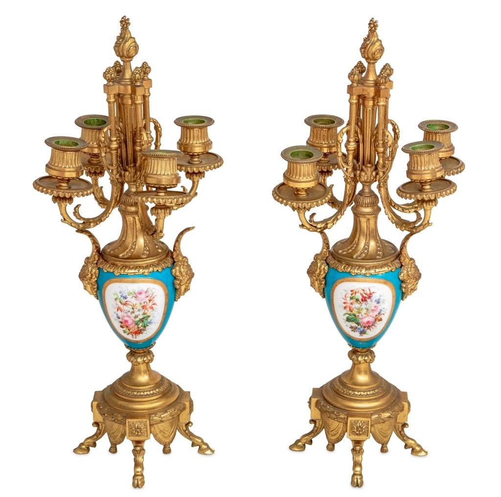 Paire de candélabres à quatre branches en porcelaine bleu céleste et métal doré, fin du XIXe siècle, chacun avec des bras de bougie à volutes sur un corps en forme d'urne avec des montures de tête de masque, des scènes romantiques peintes dans des