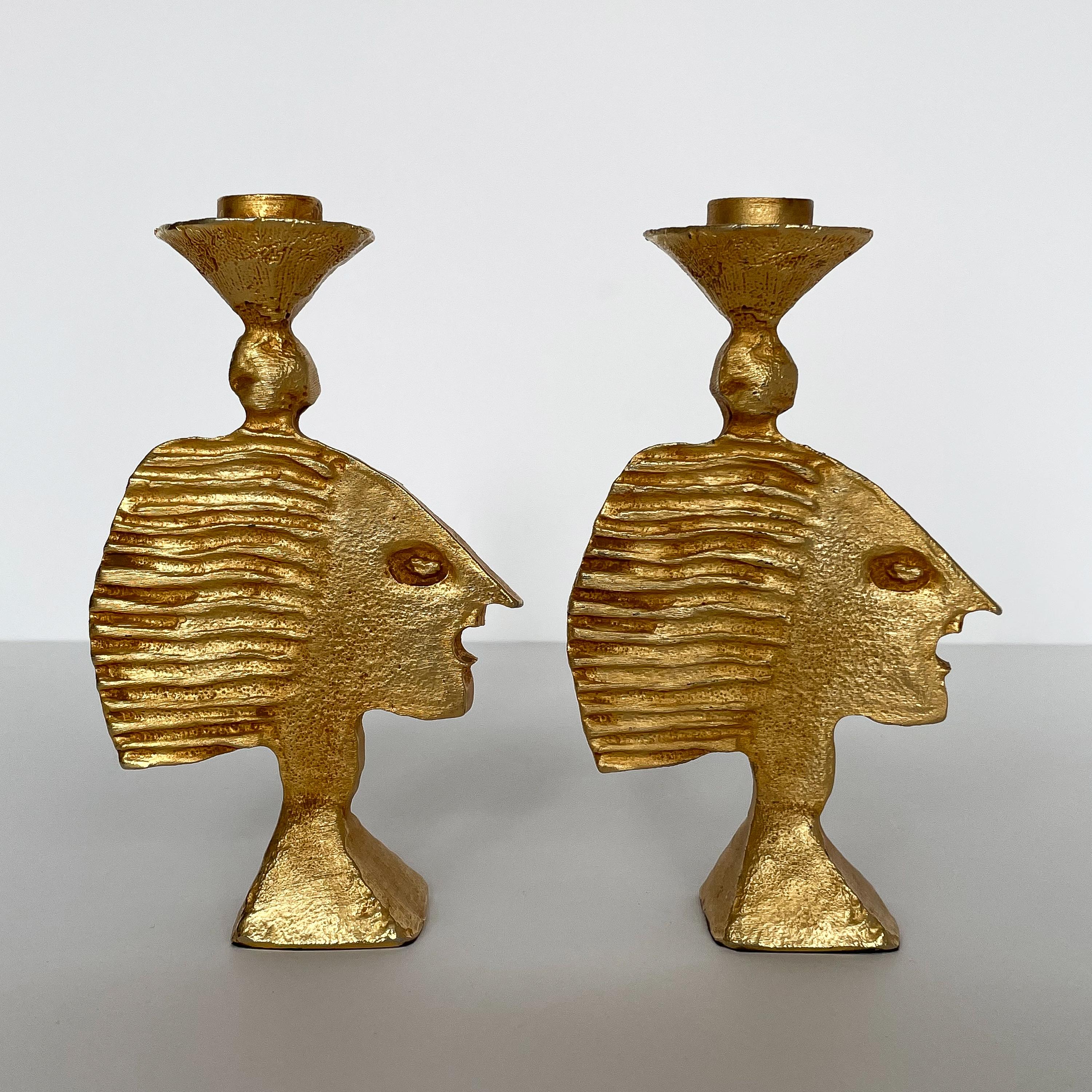 Pair of gilt metal candlesticks by Pierre Casenove for Fondica, circa 1990. These solid bronze candlesticks are gilded in gold leaf and features a stylized female face on each. Both are marked Fondica France 90. Each holds one candle and the candle
