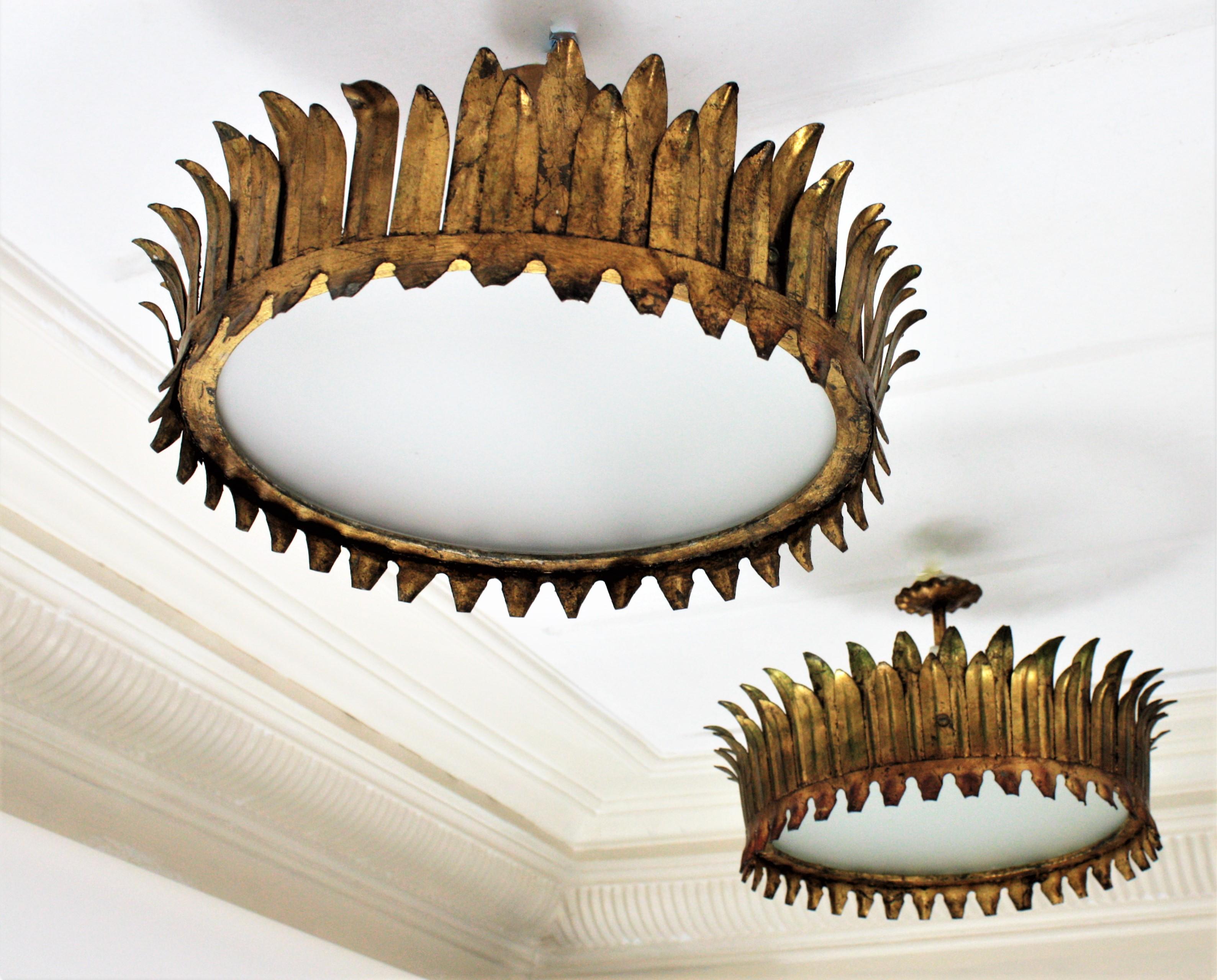 Pair of French Gilt Metal Sunburst Crown Ceiling Lights with Frosted Glass, circa 1940.
A lovely pair of neoclassical Revival gilt iron crown flush mounts with frosted glass diffussers in the central part.
They were handcrafted in France at the