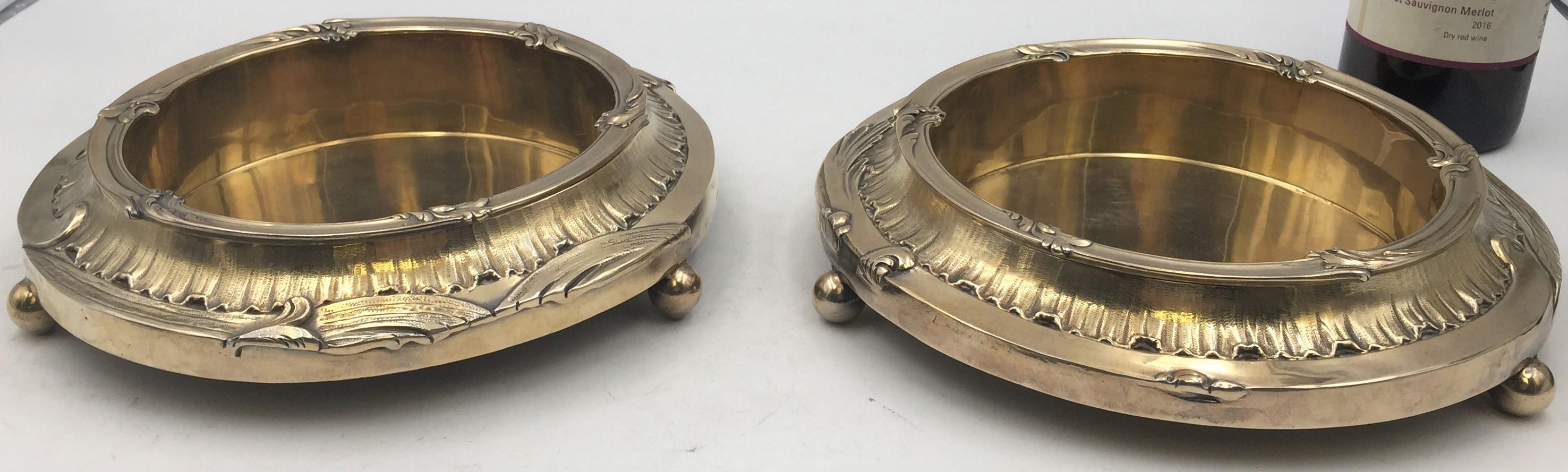 Pair of French sterling silver gilt magnum bottle coasters on stands with exquisite stylized vegetal motifs. They separate in 2 parts; the interior inserts have the French silver hallmarks, and further incised is 