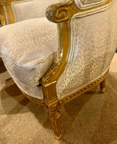 Pair of French giltwood bergere style chairs, 19 th c. With white upholstery
