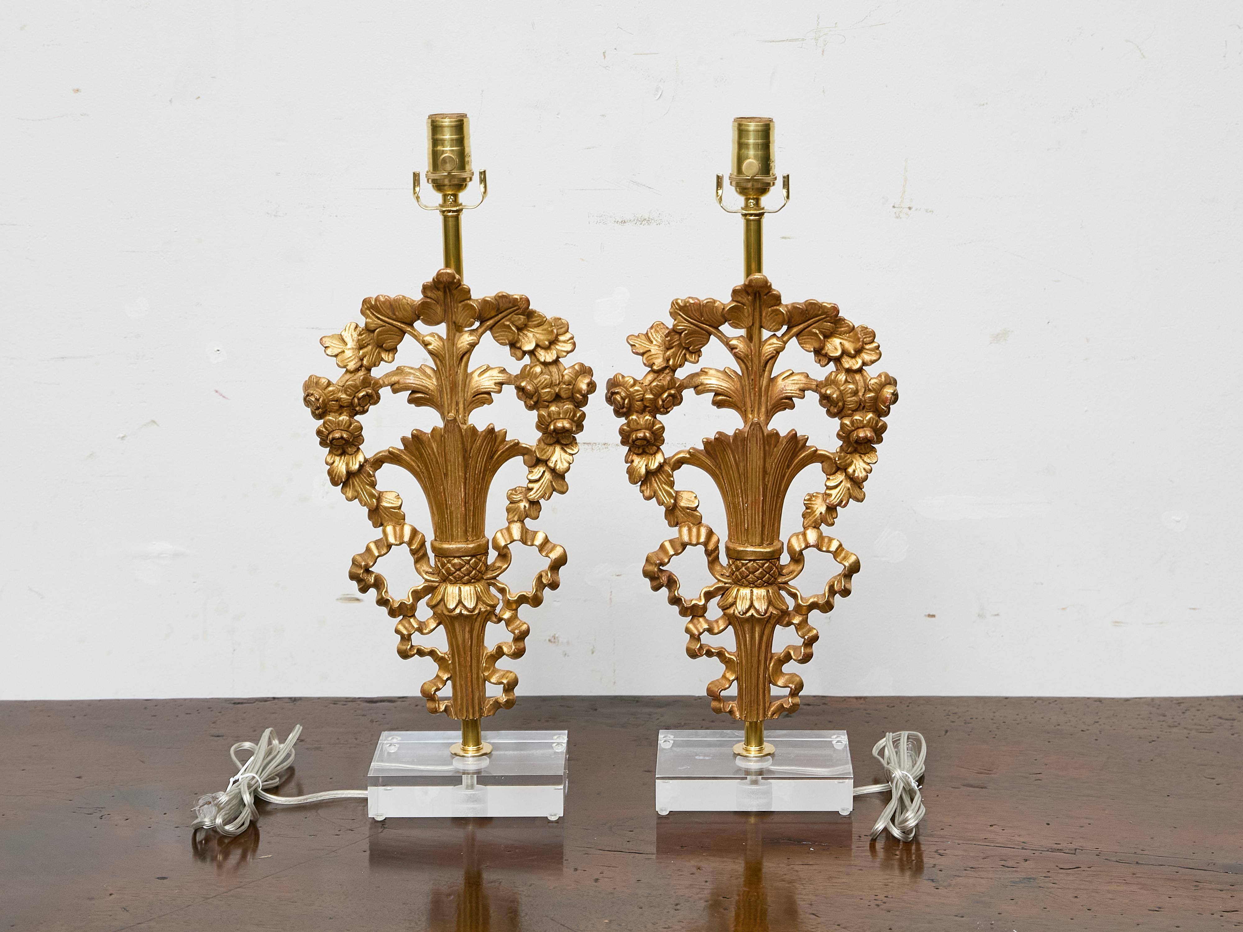 Una coppia di frammenti di legno dorato francese del XIX secolo trasformati in lampade da tavolo moderne e scultoree, montate su basi in lucite personalizzate e ricablate professionalmente per gli Stati Uniti. Queste eleganti sculture presentano