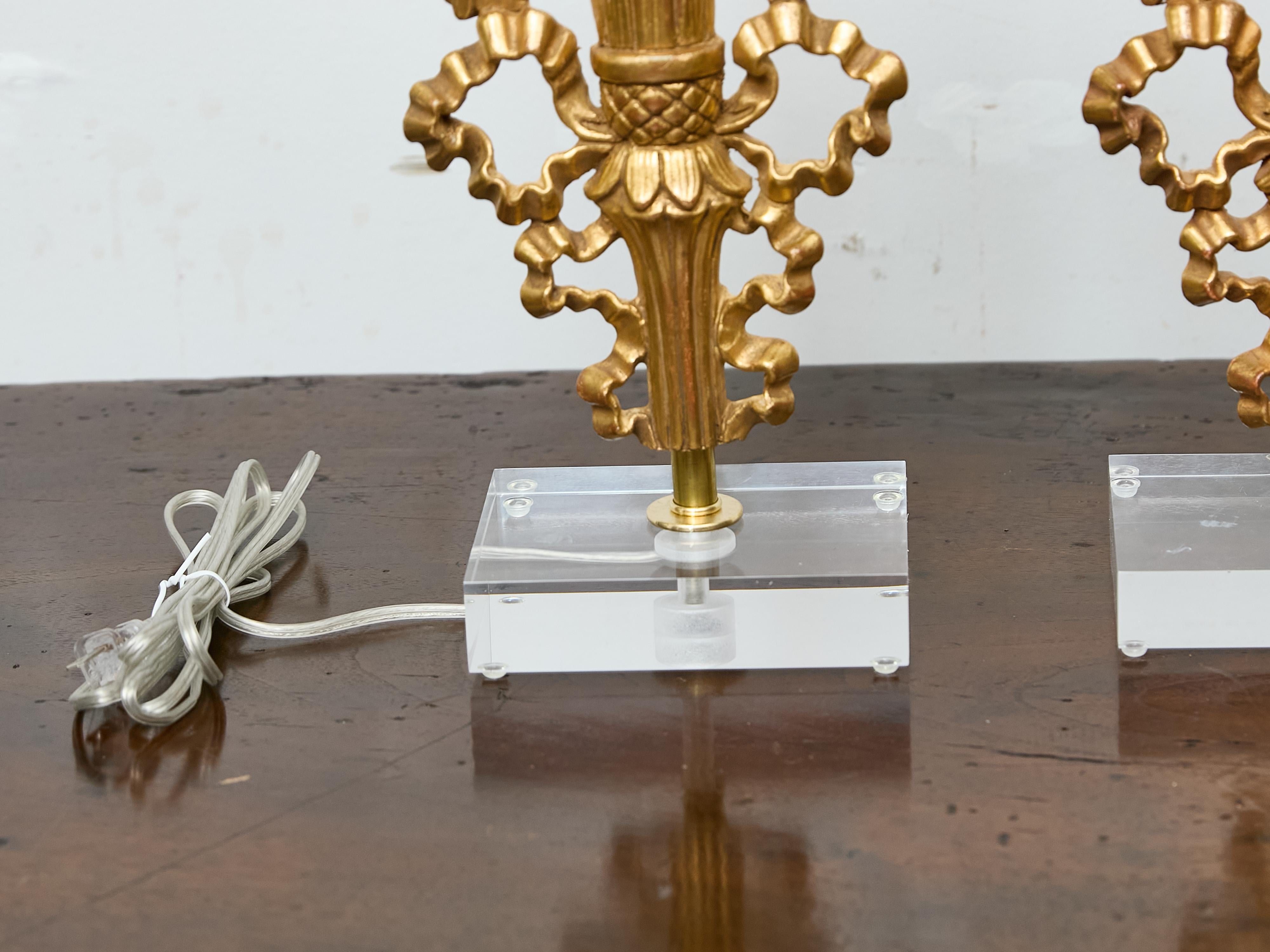 Lucite Coppia di frammenti floreali in legno dorato francese trasformati in lampade su basi in lucite personalizzate in vendita
