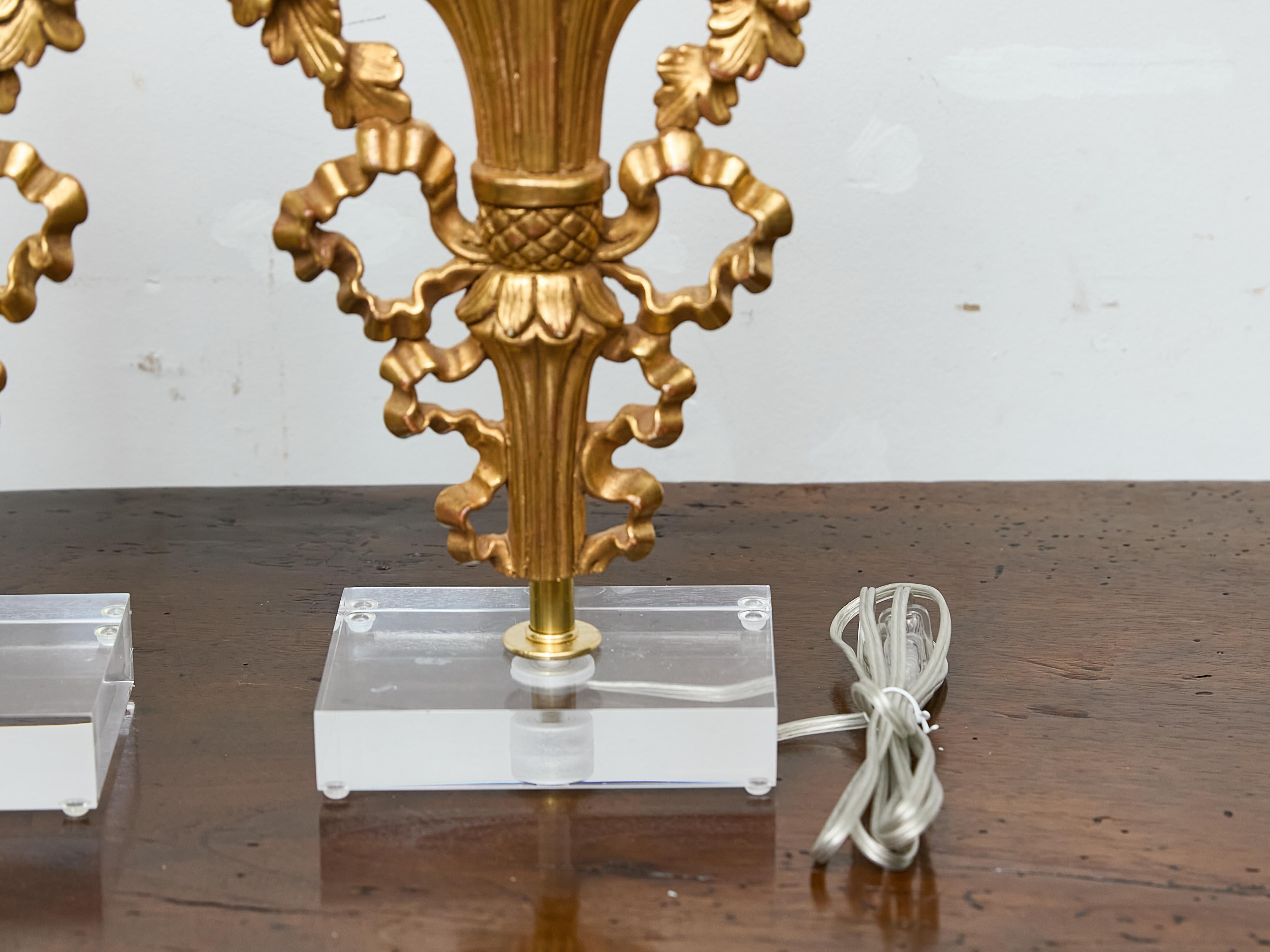 Coppia di frammenti floreali in legno dorato francese trasformati in lampade su basi in lucite personalizzate in vendita 1