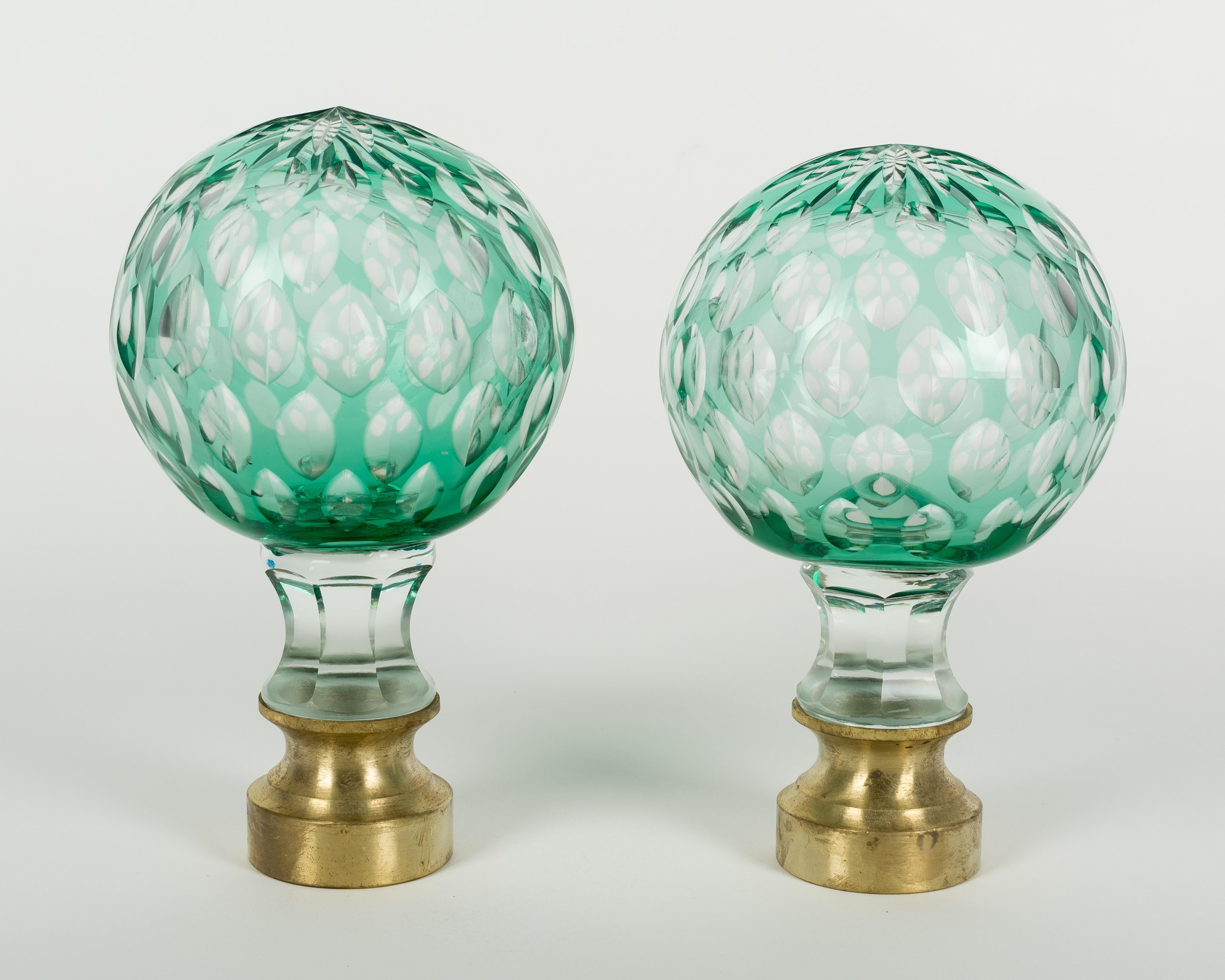 Pair of early 20th century French clear green cut-glass newel post finials or boule d'escalier with a multi-cut star at the top. These wonderful finials were used as decorative elements at the bottom of a staircase on the newel post. Brass hardware
