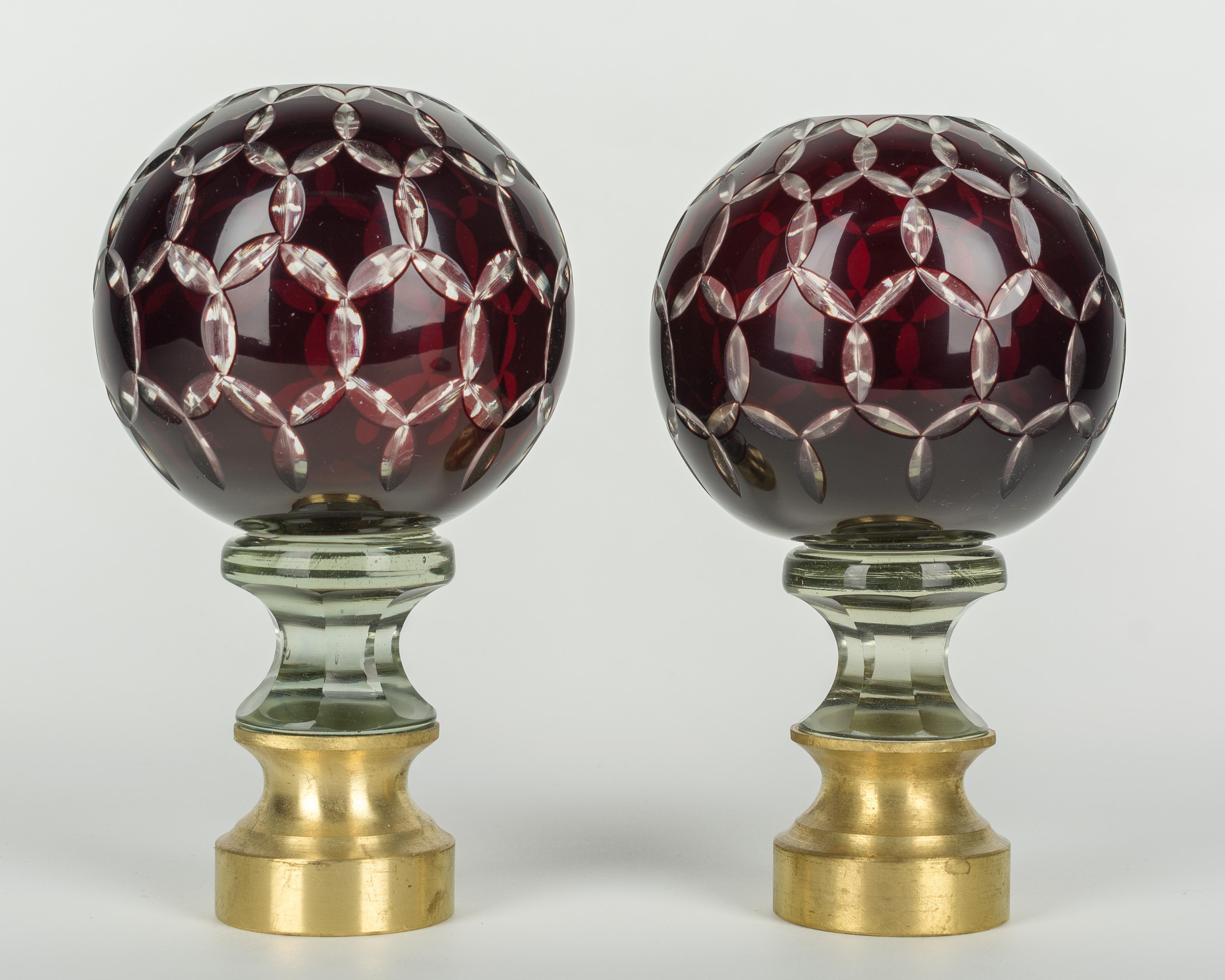 Ein Paar französische Boules d'Escalier aus geschliffenem Glas aus dem frühen 20. Jahrhundert. Klares Glas mit einer äußeren Schicht aus tiefem Rubinrot und einem mehrfach geschliffenen Stern an der Spitze. Diese wundervollen Endstücke wurden als