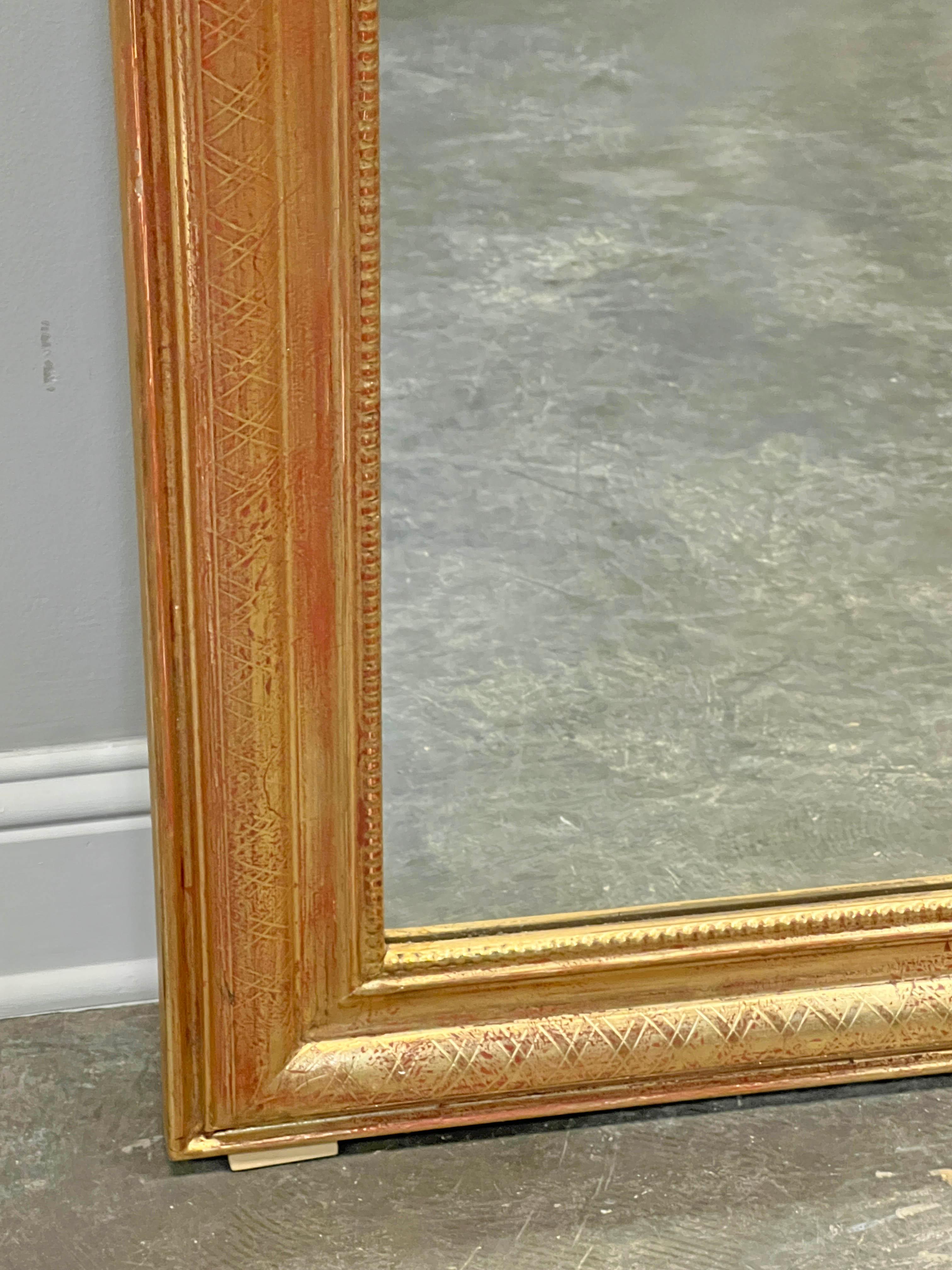 Pair of French gold gilt arched mirror with trellis design on the frame and beading along the inside border. Great over a pair of console, chests or even sinks.