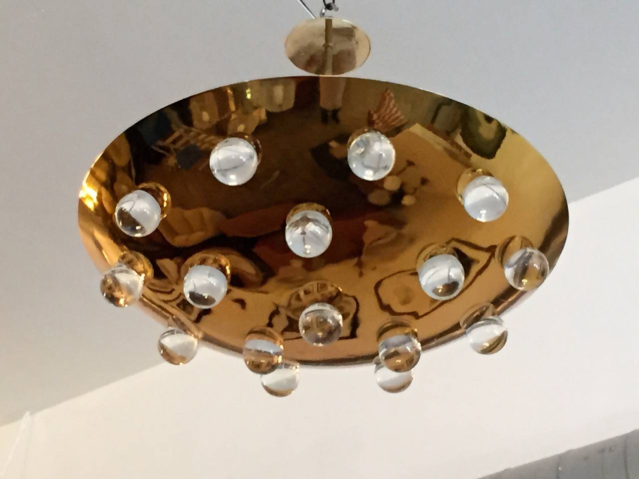 A wonderful pair of 1960s French gold-plated brass round disc fixture with 16 solid glass orbs. Five-light sources which emit light downward through the glass as well as up toward the ceiling. The ceiling pole can be lengthened or shortened. Rewired