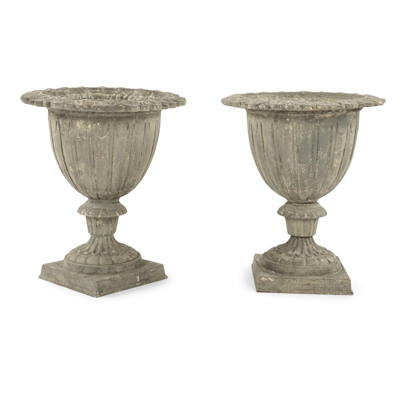 Pair of French gray-painted cast iron garden urns circa 1910. They feature an unusual, whimsical shape, beautifully decorative rims and a rich patina. Sold together and priced $4,400 for the pair.

Note: Original/early finish on antique and vintage