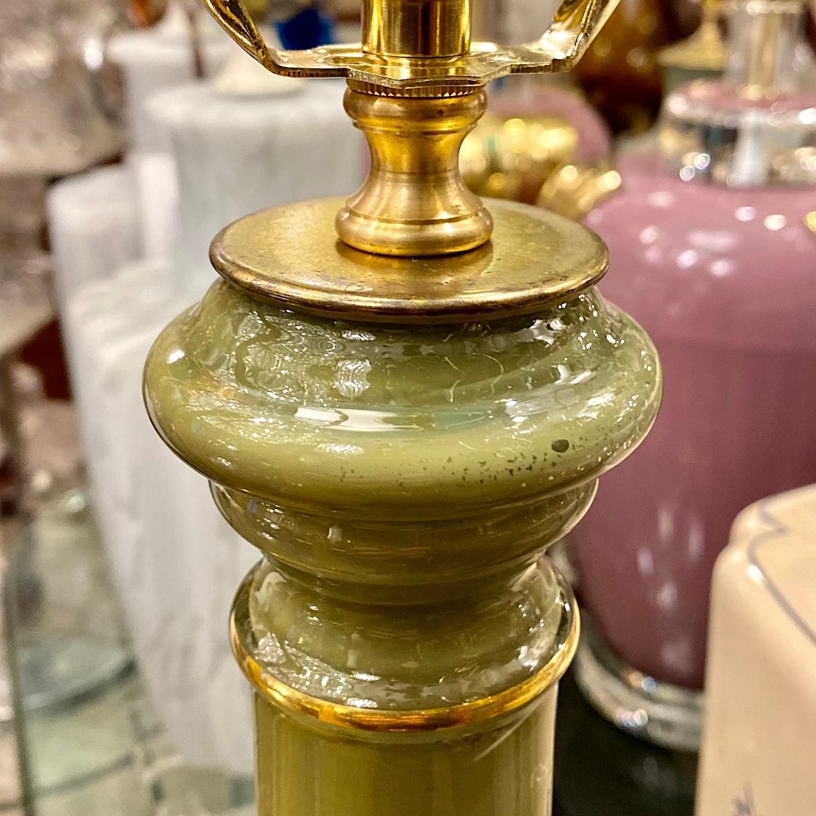 Pair of circa 1950's French glass lamps, green body with gilt details.

Measurements:
Height: 19.5
Height to shade rest: 30
