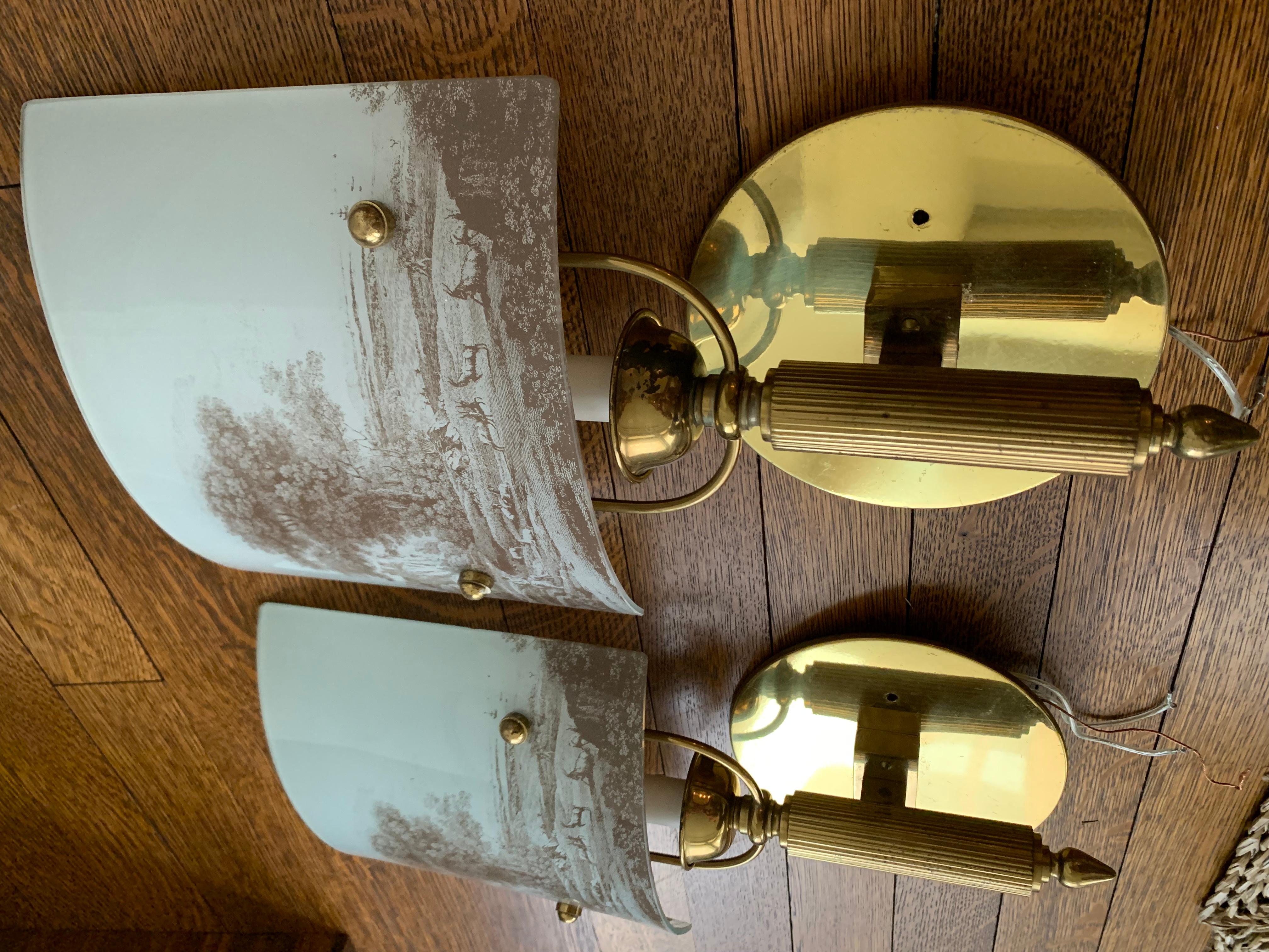 Pair of brass and glass French Grisaille vintage scenic sconces. Each sconce takes (1) E12 base bulb and are US hardwire ready.