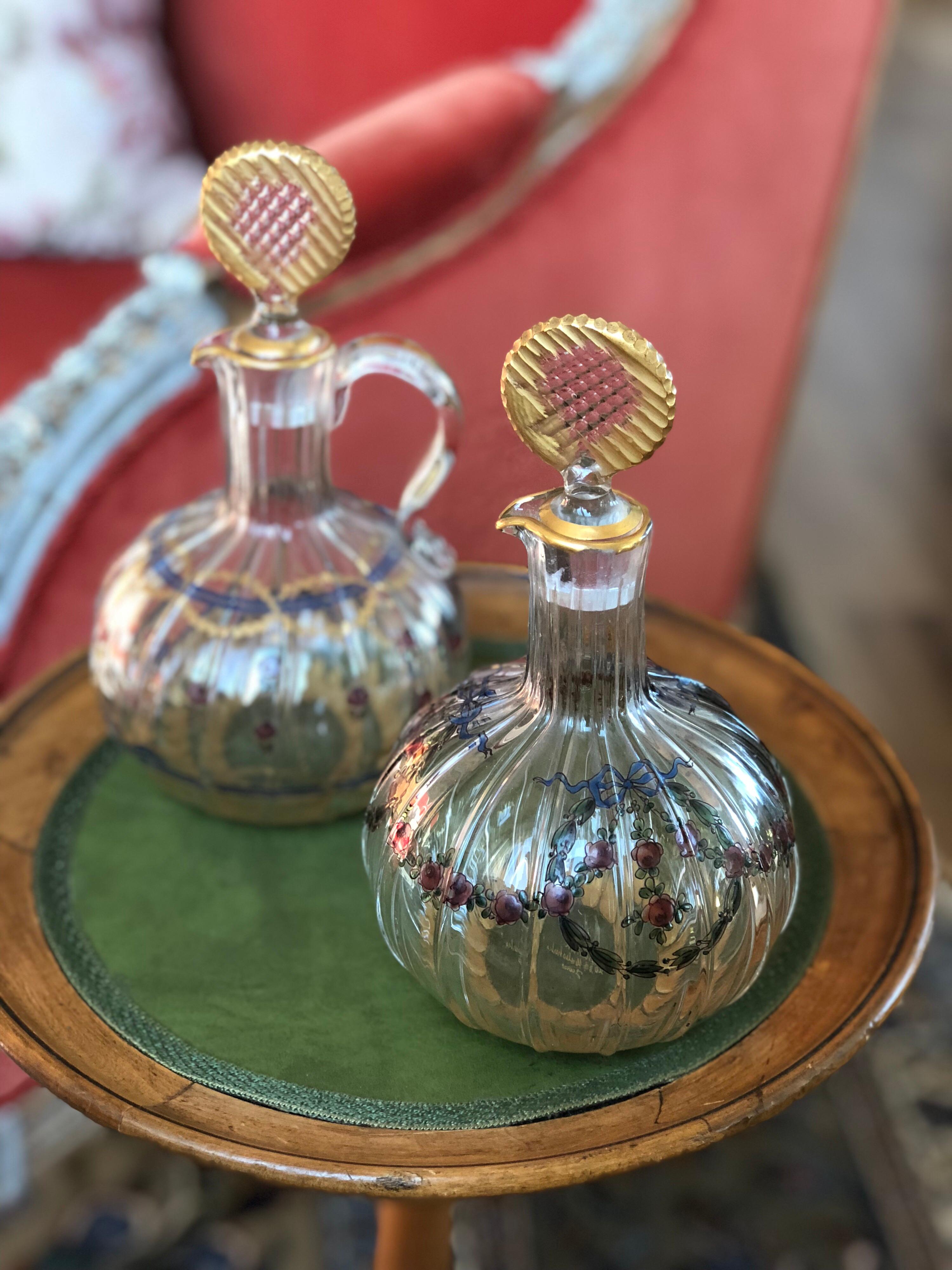 Due piccole caraffe di vetro con costole e tappi laterali decorati con ghirlande e rose e macchie di doratura. Firmato DAMON e DELENTE 20 boulevard Malesherbes Parigi
Misure: H. 20 cm.