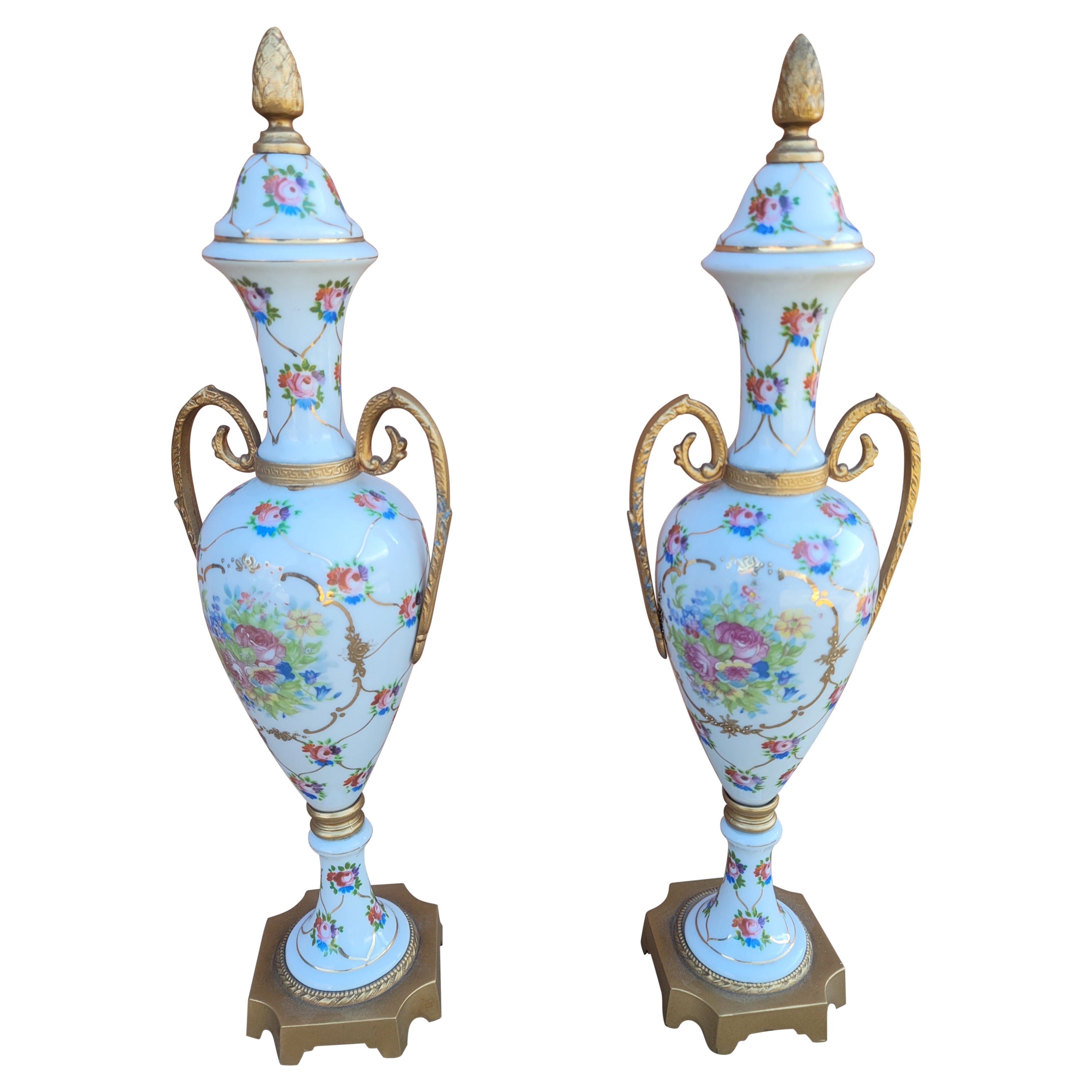 Pareja de ánforas francesas de porcelana pintada a mano y metal dorado