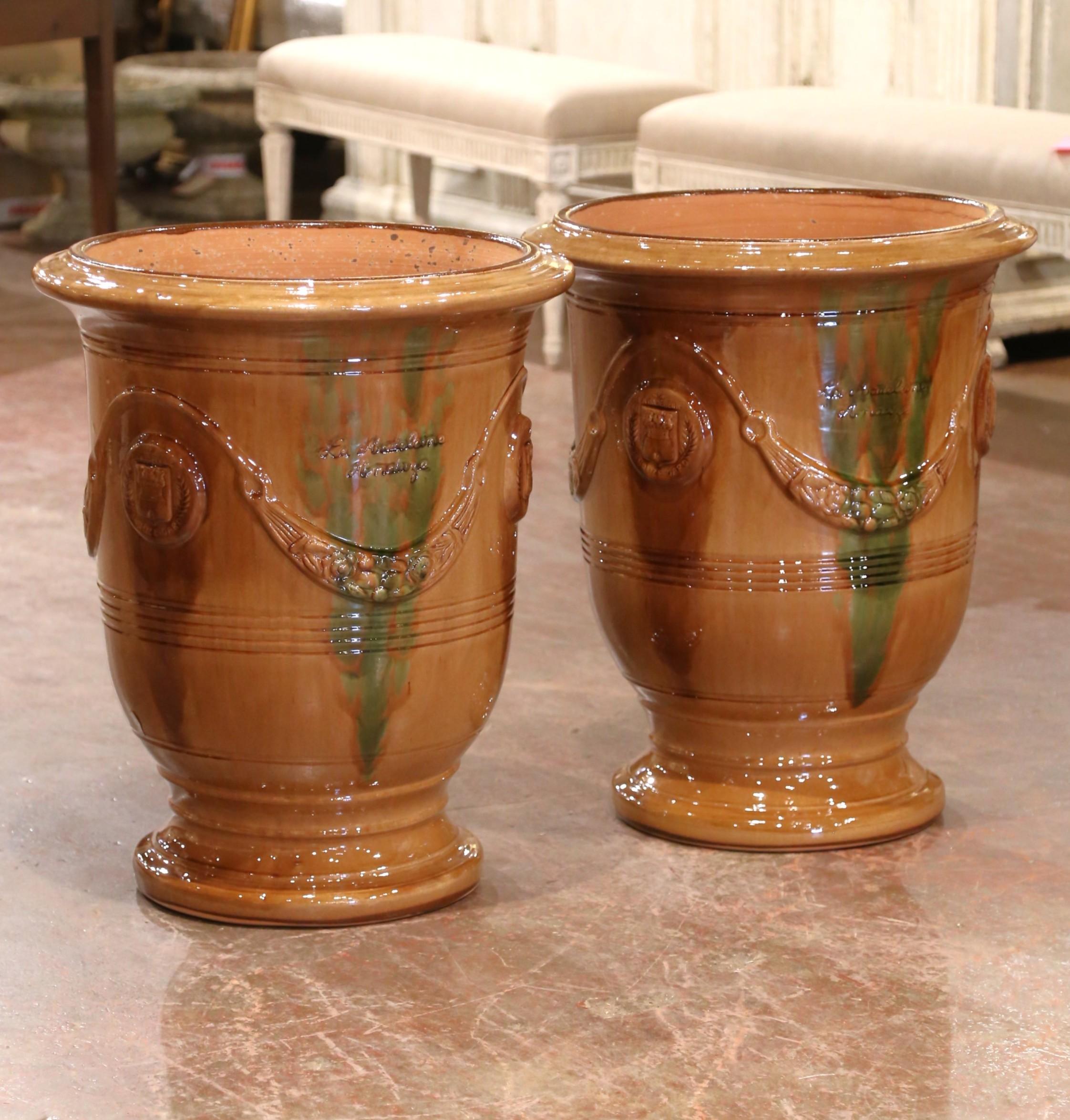 Dieses Paar handgefertigter Anduze-Pflanzgefäße von La Madeleine bringt zeitlose provenzalische Eleganz in Ihren Garten oder Ihr Interieur. Jedes Gefäß wird in Südfrankreich nach traditionellen Techniken aus Terrakotta geformt und mit einer