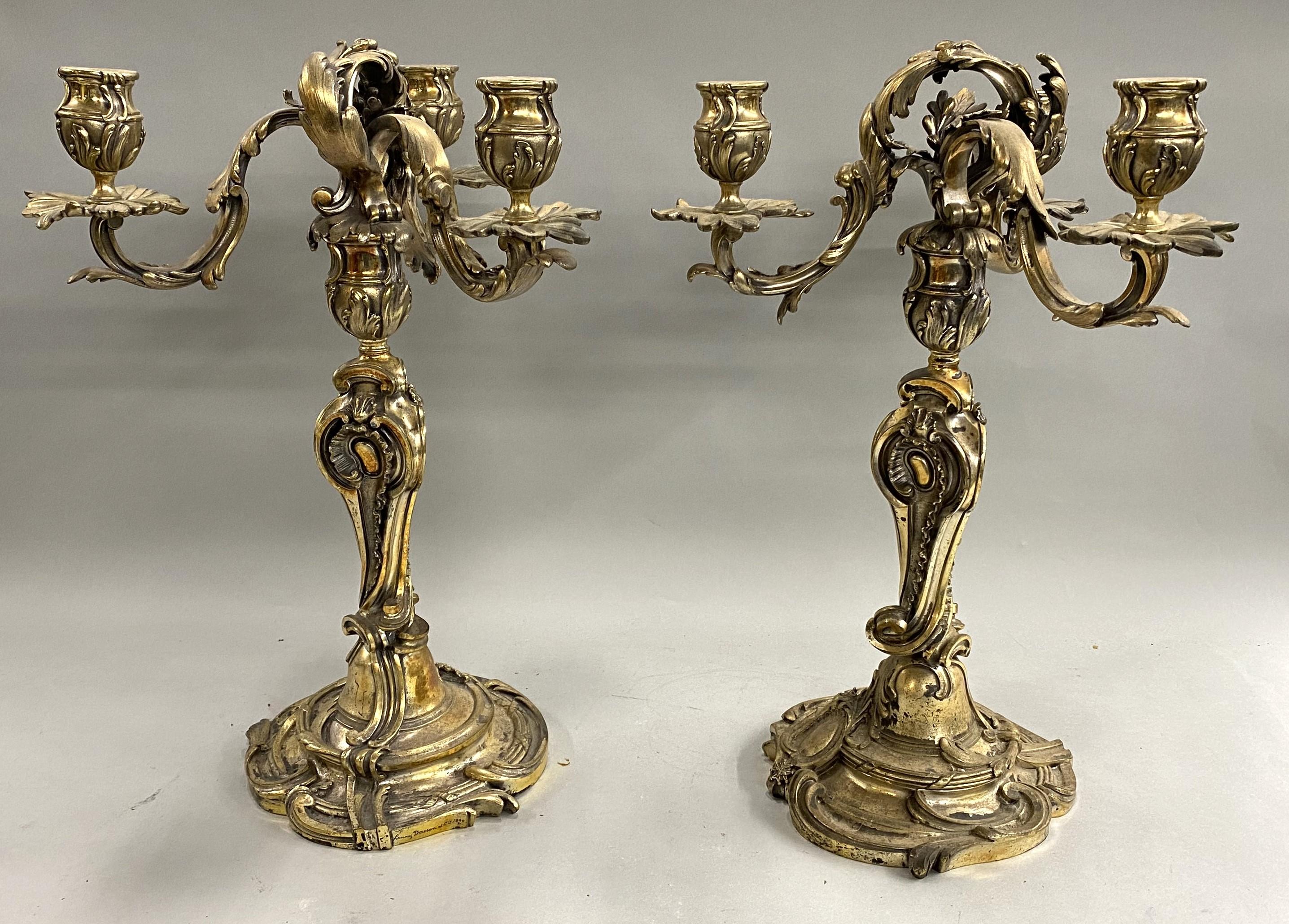 An impressive pair of French gilt bronze three-light candelabra in a foliate motif, signed “Henry Dasson et Cie 1892” on the base. Henry Dasson. Henry Dasson (c. 1825–1896) was a nineteenth century Parisian maker of gilt-bronze mounted furniture.