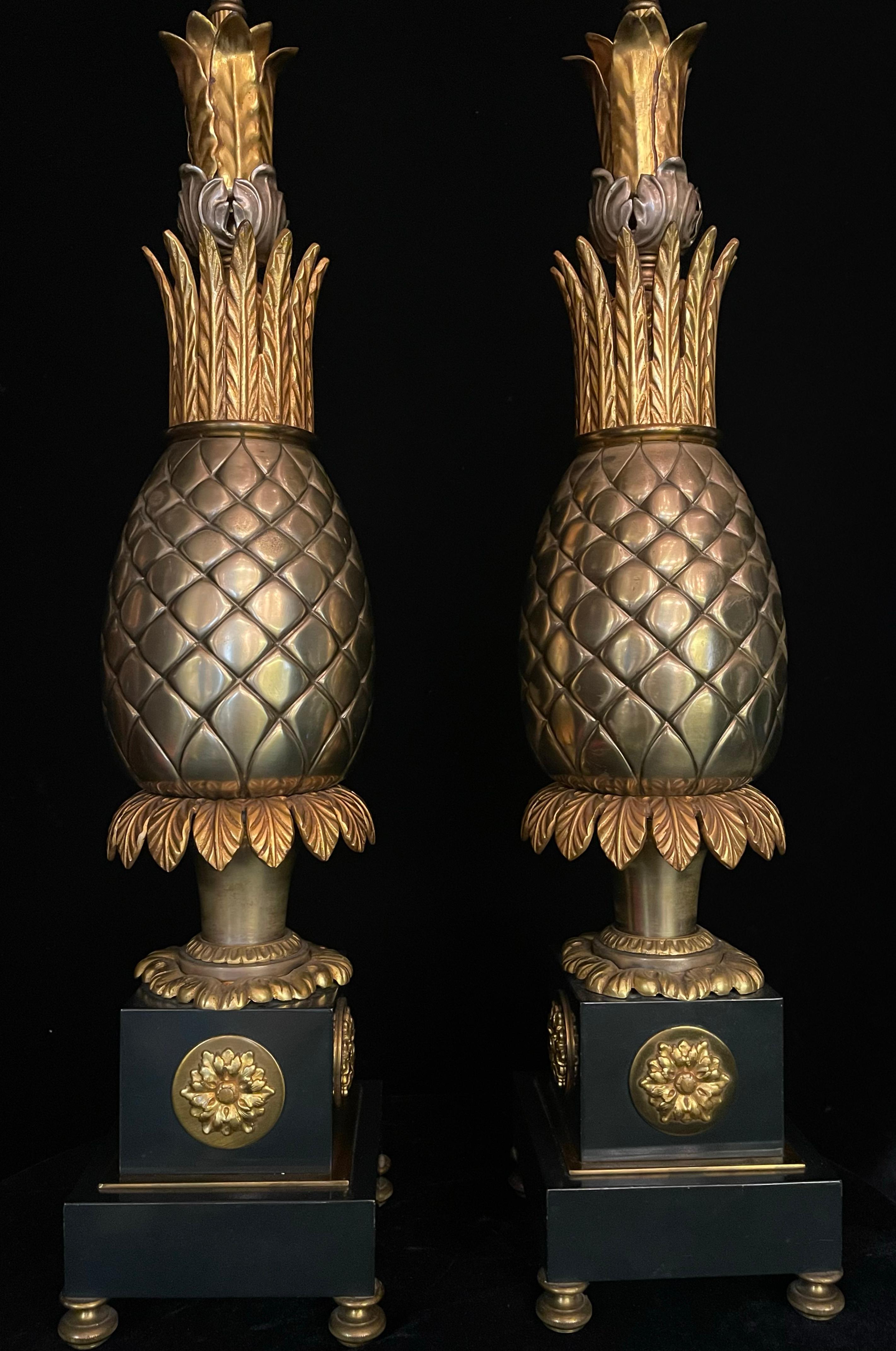 Ein prächtiges Paar französischer Hollywood-Regency-Lampen aus vergoldeter und patinierter Bronze mit Ananas. Jede Leuchte ist in der Form einer stilisierten Ananas gegossen, einem klassischen Symbol der Gastfreundschaft und des Überflusses. Die