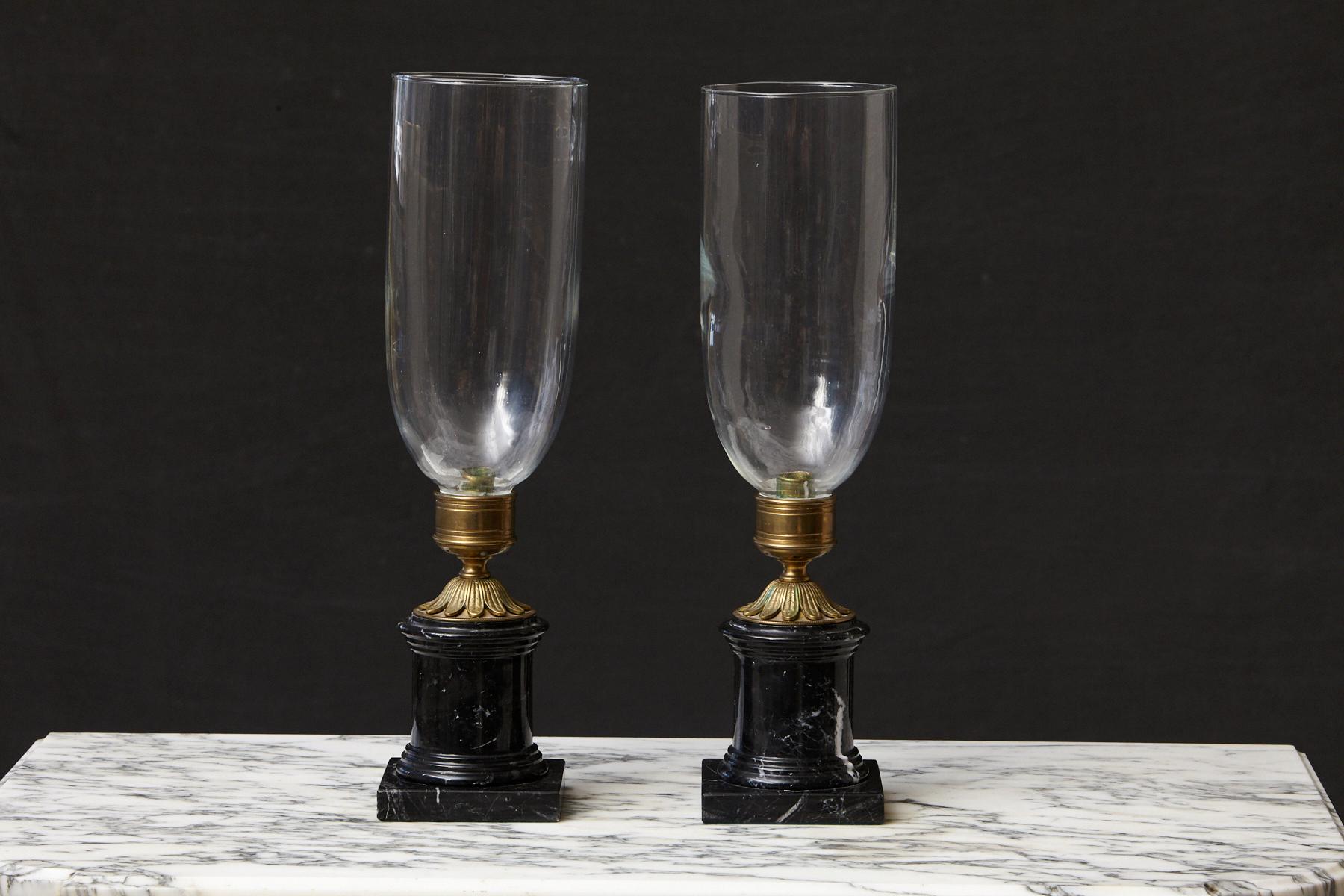 Lovely pair of tall French hurricane candle lamps with handblown clear glass shades mounted on black marble bases with ornamental brass sockets, circa 1920s.
Opening glass cylinder 5.65 inches.
Very good condition.