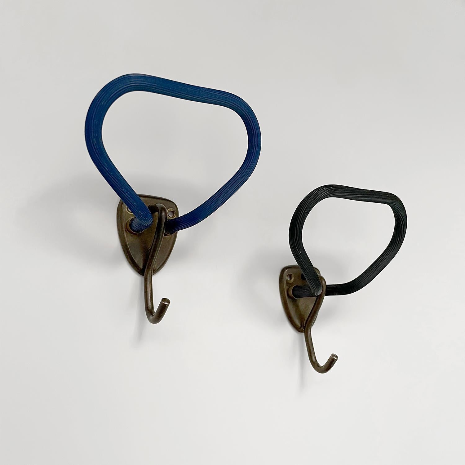 Pair of French industrial wall hooks
Rounded triangular upper arm is covered in a ridged tactile material 
Contrasted with an aged bronze petite j hook
Each wall mounted hook is supported by a single shield shaped bracket which requires two screws