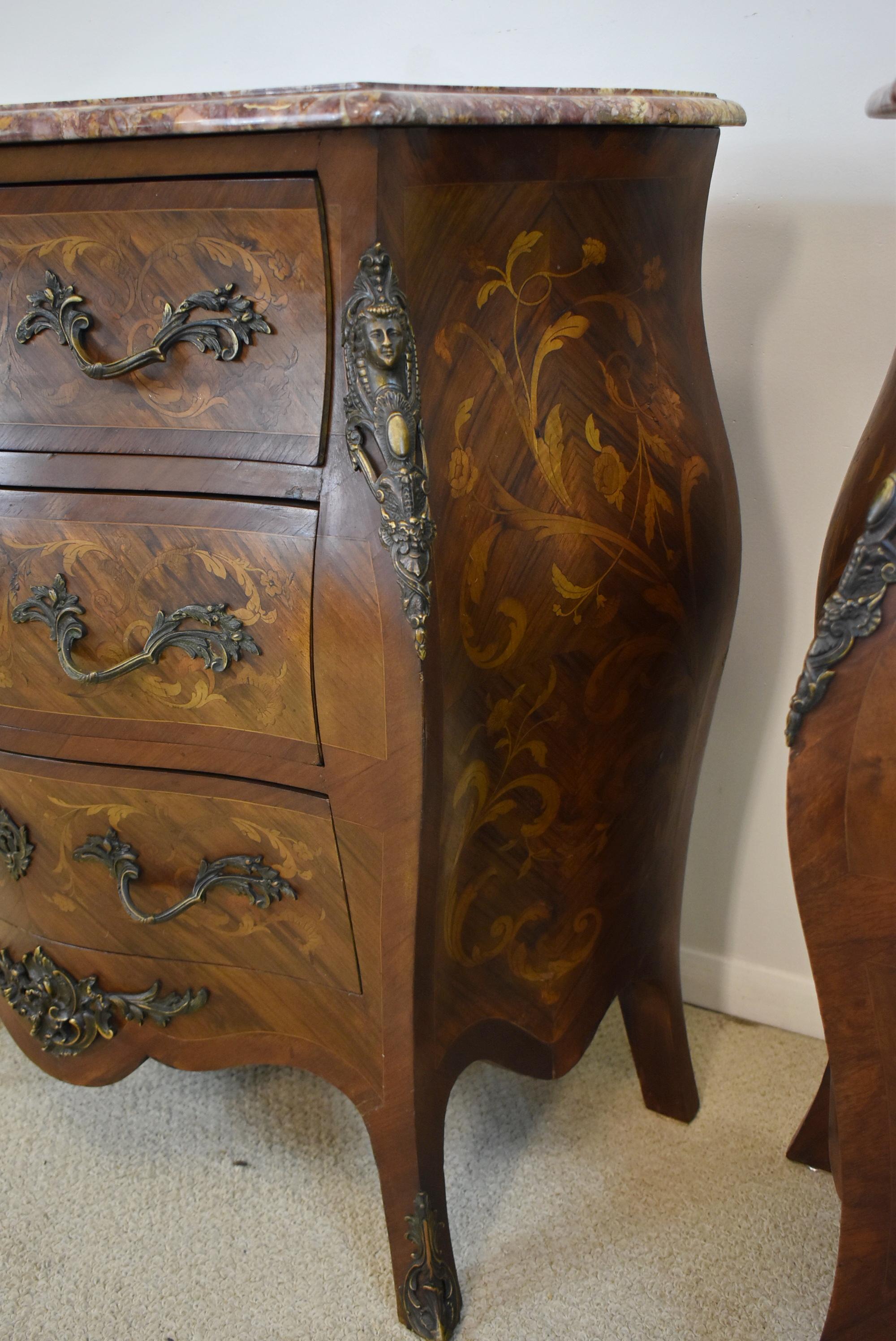 A pair of mid 20th century French Louis XV style Bombay commodes. Walnut and tulipwood construction with great marquetry inlaid foliate detail on the drawers and sides cast Bronze handles and mounts. Each commode has three dovetailed drawers and