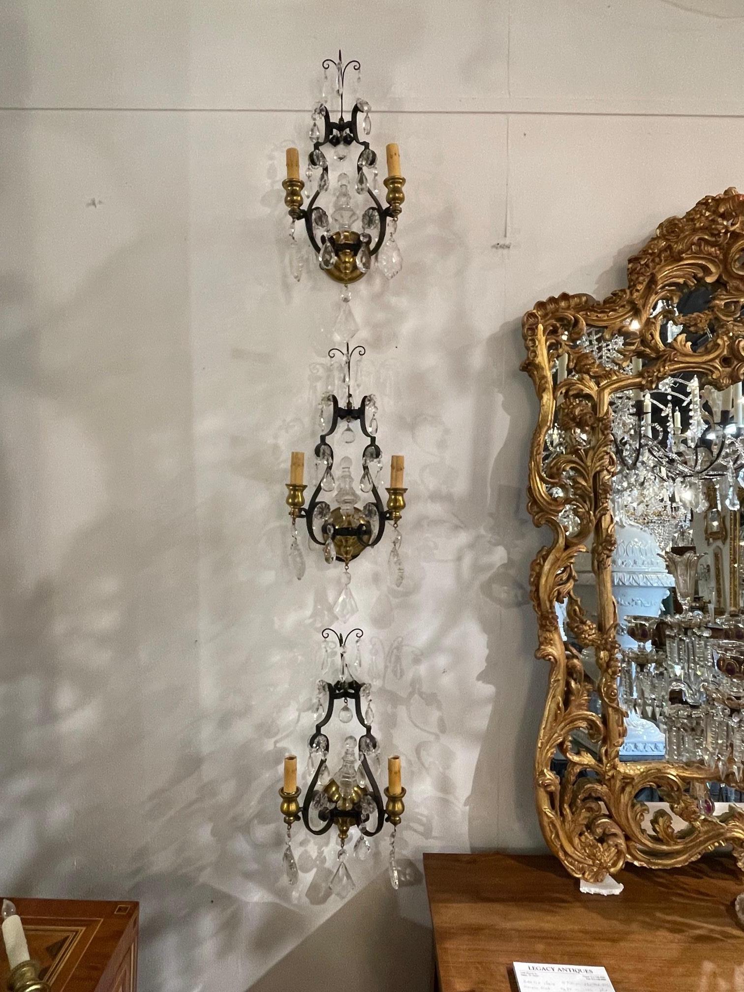 Pair of French iron and bronze 2 arm sconces. Circa 1900. The sconces have been professionally rewired and ready to hang.