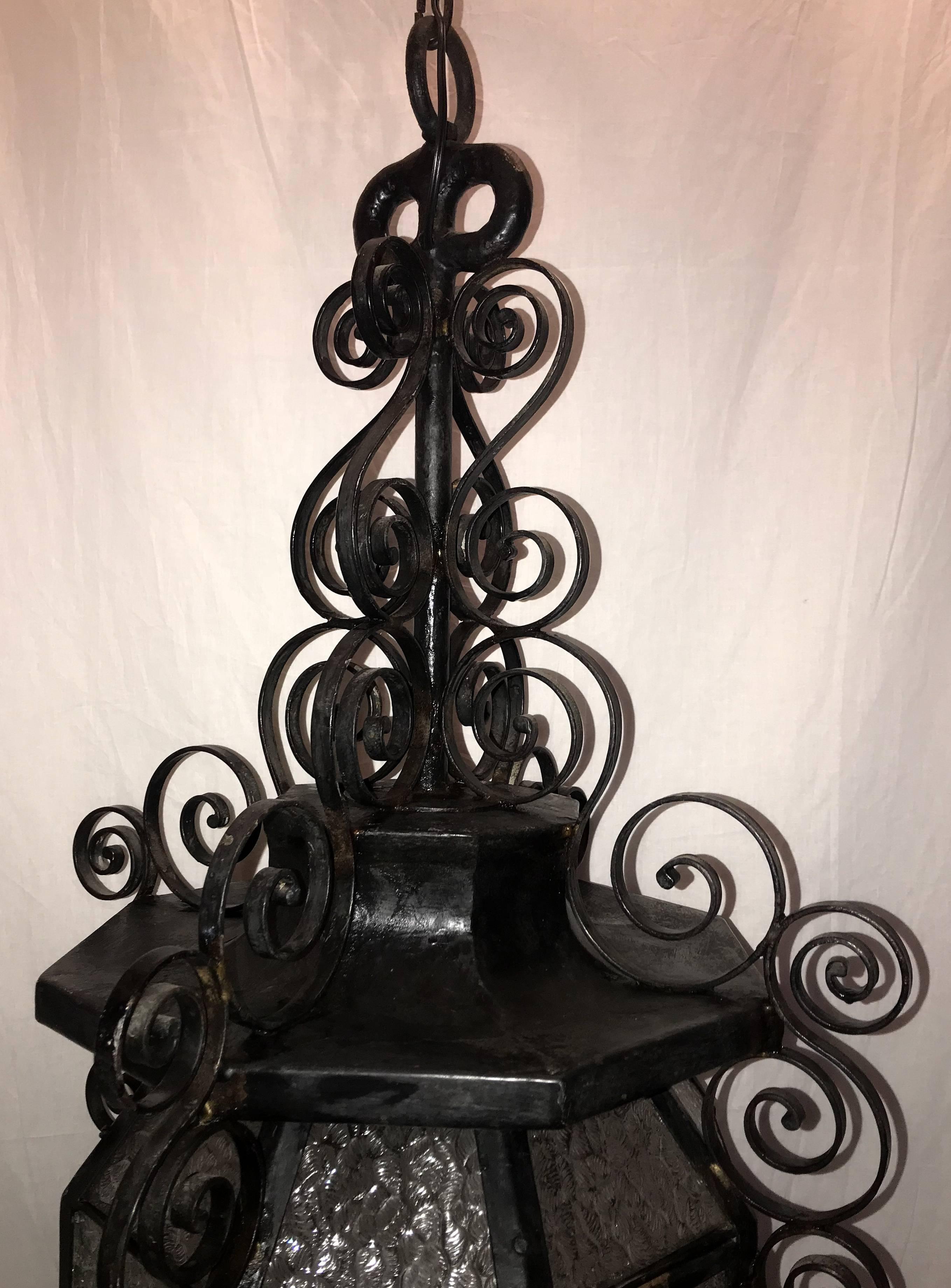 A wonderful pair of French iron scroll fixtures in the Art Nouveau motif, with glass panels set into each pagoda lantern form each with three candelabra lights.

Each sold individually.