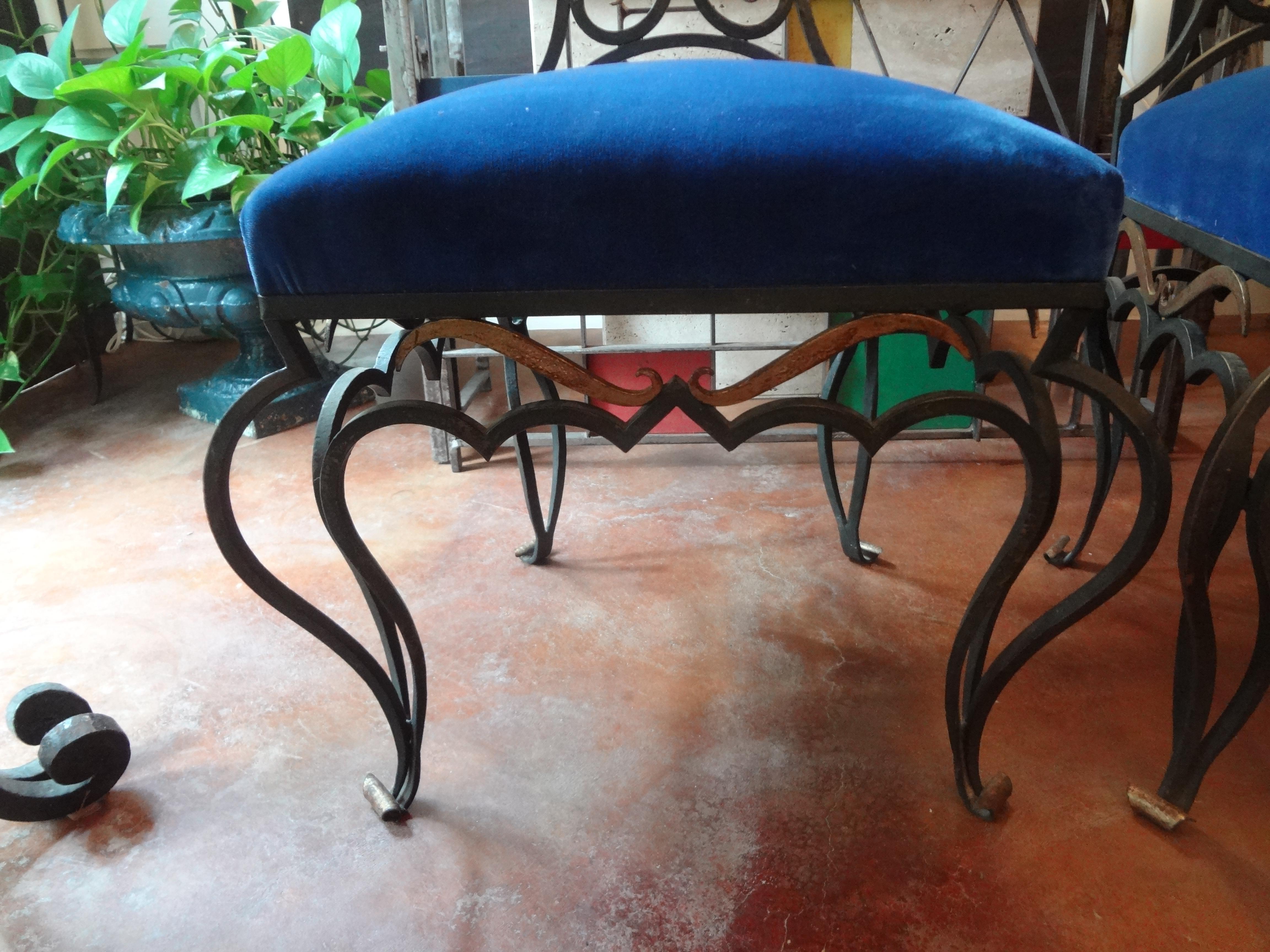 Superbe paire de chaises latérales en fer forgé attribuées à Jean-Charles Moreux. Ces fabuleuses chaises en fer forgé forgées à la main ont juste une touche de dorure et ont été nouvellement tapissées dans un beau velours bleu. Ces élégantes chaises