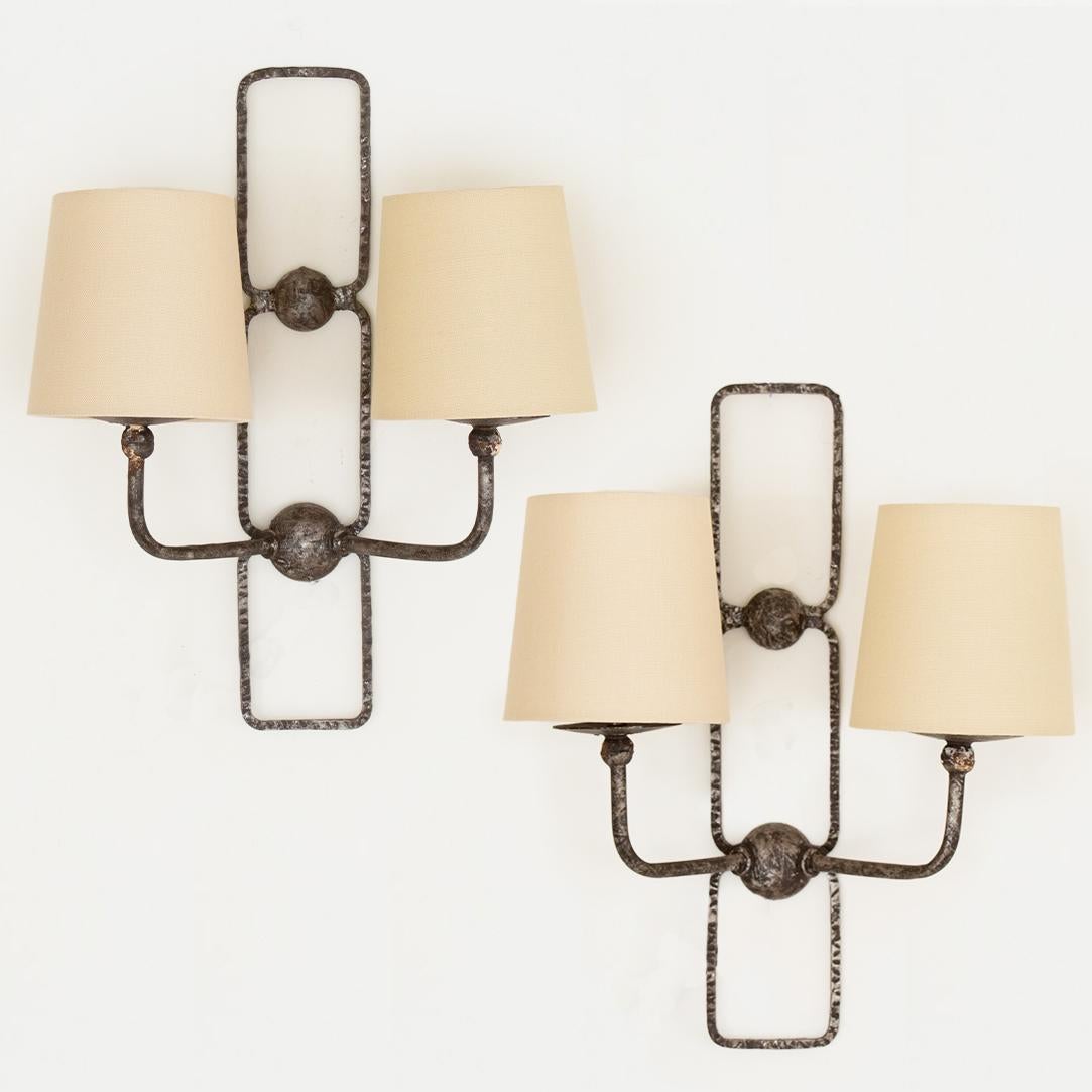 Great pair of geometric iron sconces made in France. Art Deco style with two arms on each sconce and new linen shades. Newly re-wired. Wires come out of lower circle in center which is 1.875