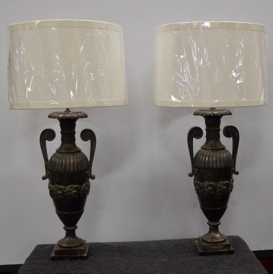 Pair of French Iron Neo-Classical Double Handle Urn lamps on marble bases made in the turn of the 20th Century.
Lamp Shades are not included.