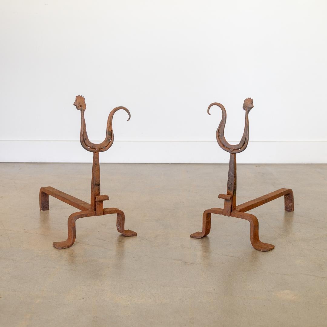 Unique pair of andirons by Atelier Marolles from France, 1950's. Heavy forged iron with whimsical rooster motif. Surface shows great age, rust and patina. 
