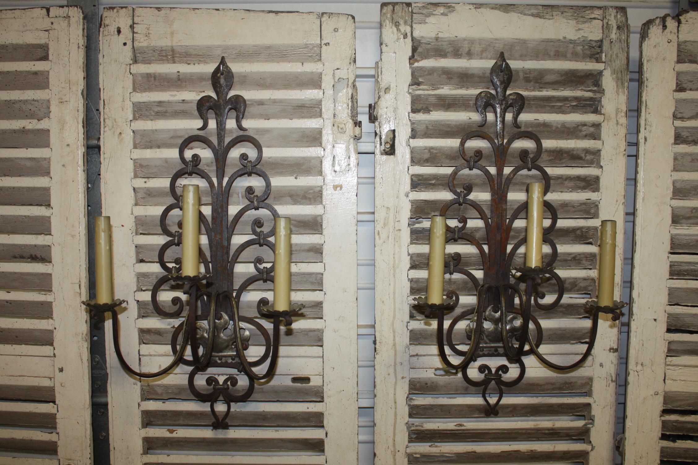 Amazing work on those pair of sconces with a Fleur de Lys on the top. Made of iron and silver metal with the patine of age.
 