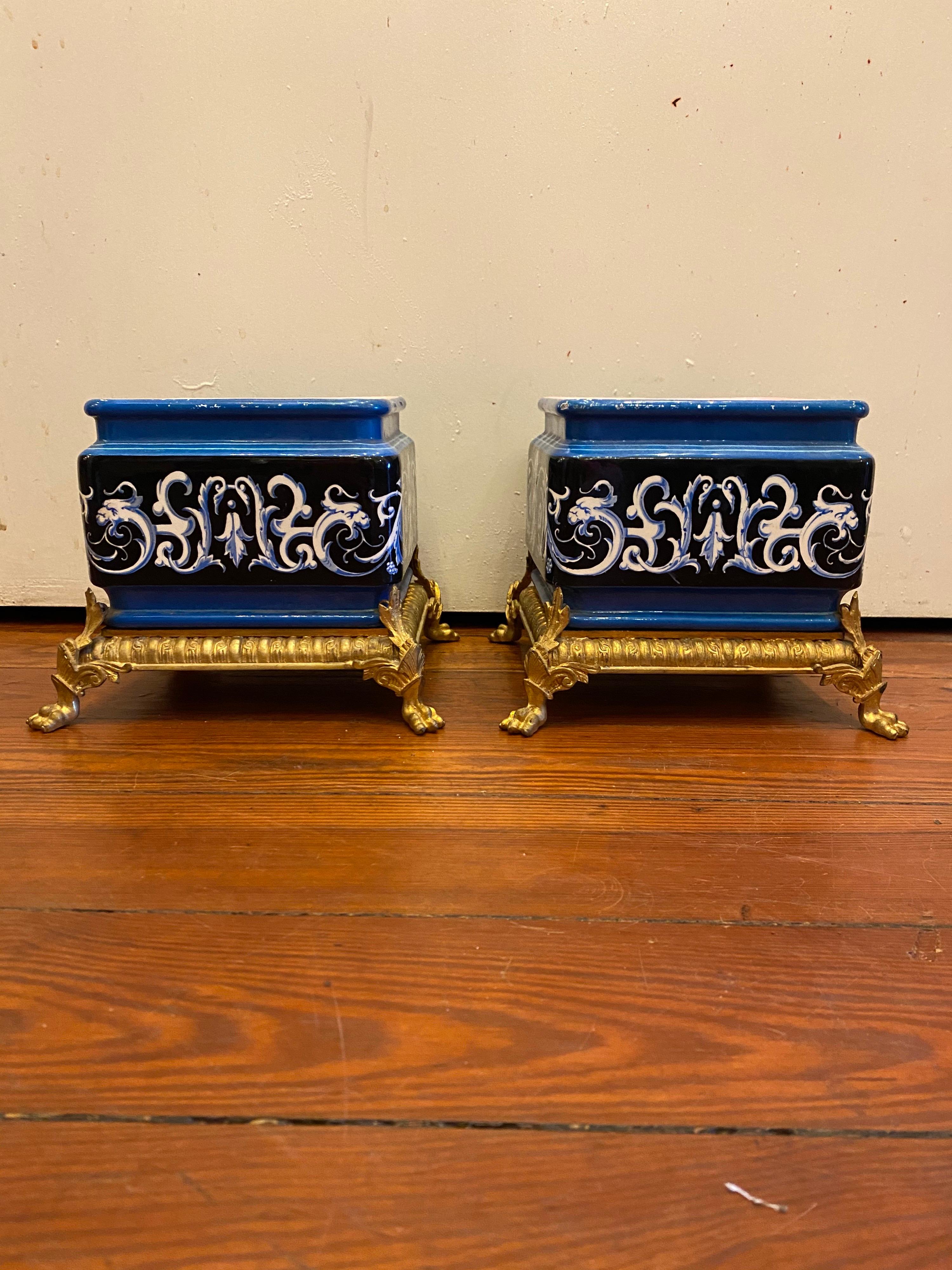 Pair of French Majolica jardinière of unusual blue with white and black decoration and pink interiors. They have exceptional gilt bronze mounted bases.
