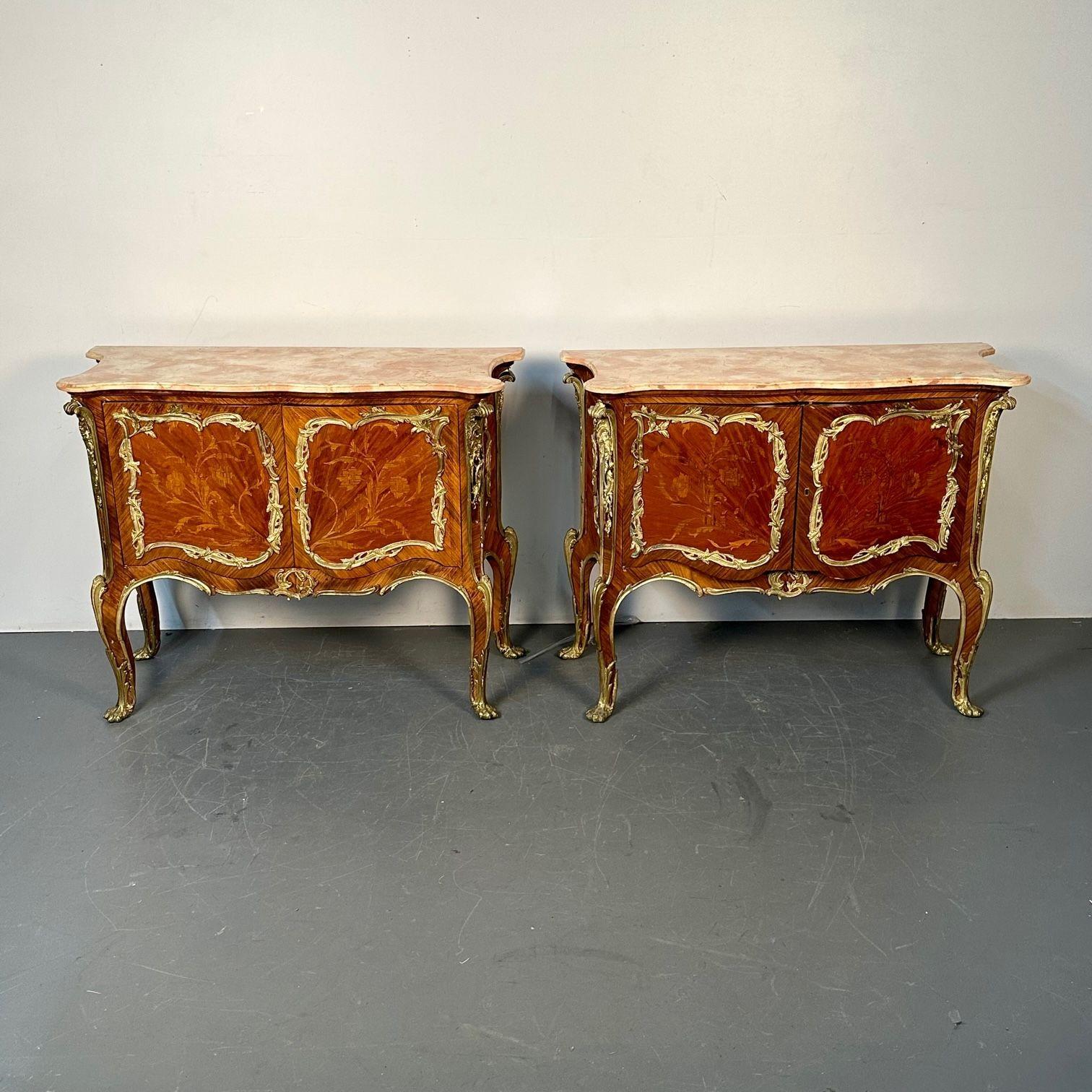 Pair of French Kingwood Bronze Mounted Commodes / Chest of Drawers or Bedside Stands
1960s, each with a shaped marble top above a conforming case fitted with two cabinet doors, each featuring an inlaid floral spray and opening to a shelved interior,