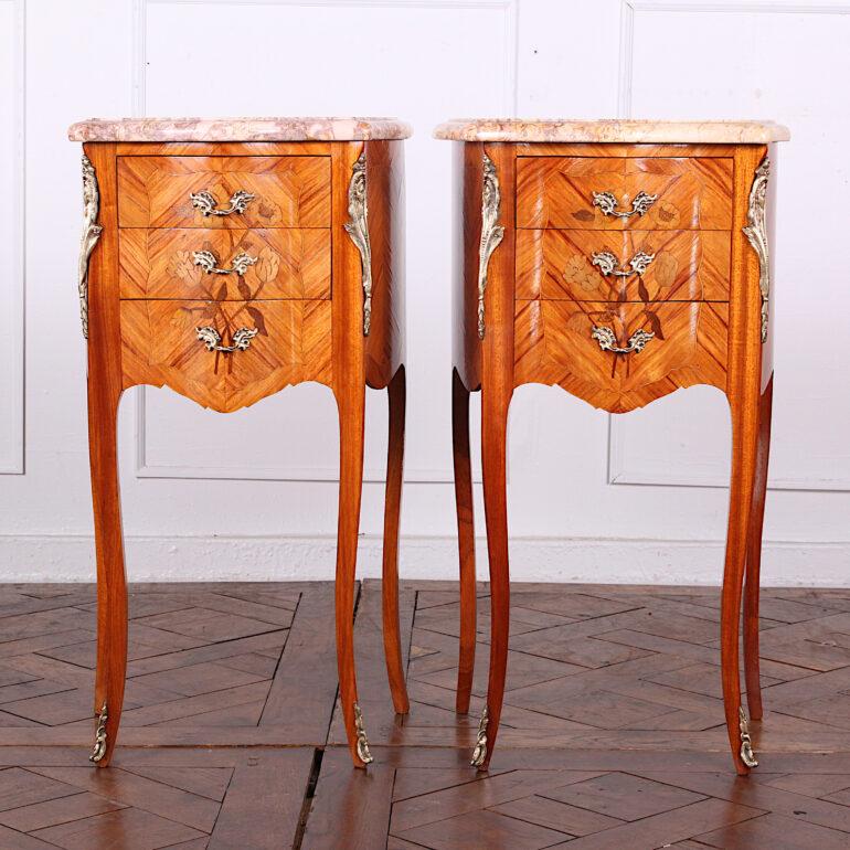 Matched Louis XV style kingwood nightstands, each with three drawers featuring floral marquetry on a book-matched kingwood ground. The pieces retain their original marble tops and are embellished with decorative finely-detailed gilt mounts and