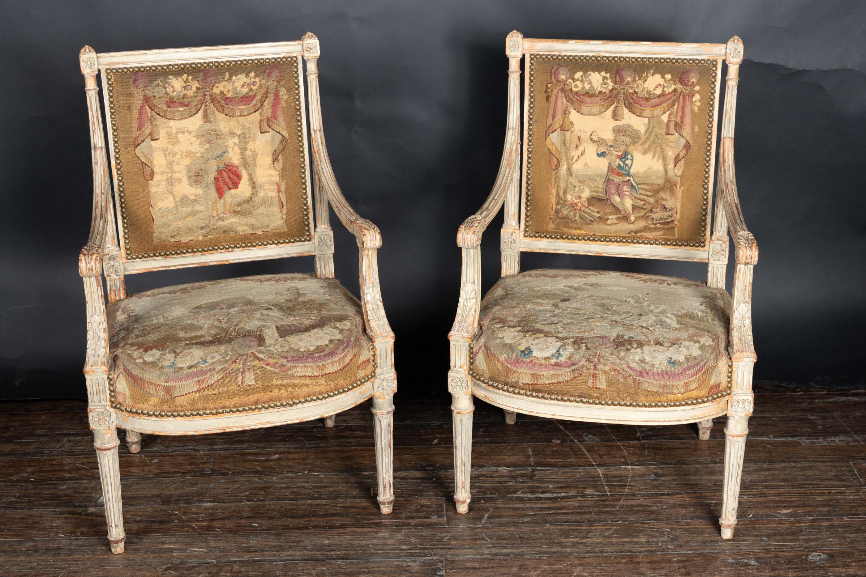 Small pair of  French late 18th century Louis XVI carved and painted fauteuil armchairs, with marguerite square at top of each side of back, as well as top of each of the fluted legs.  The arms are finished with acanthus leaves. Chairs are