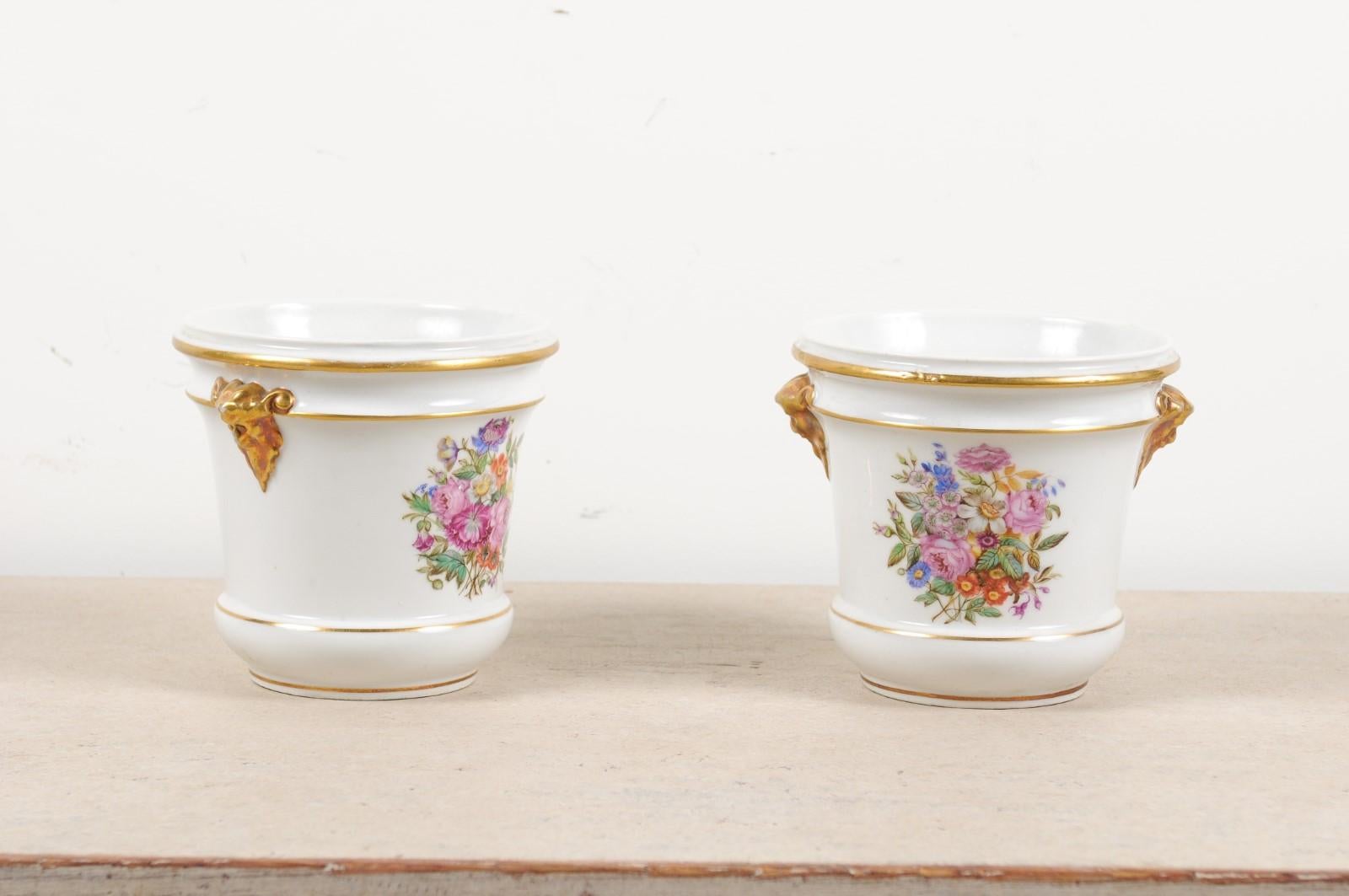 A pair of French Louis XVI period Paris porcelain cachepots from the late 18th century, with hand-painted floral décor and gilt accents. Created in France during the short reign of King Louis XVI, each of this pair of cachepots features a circular