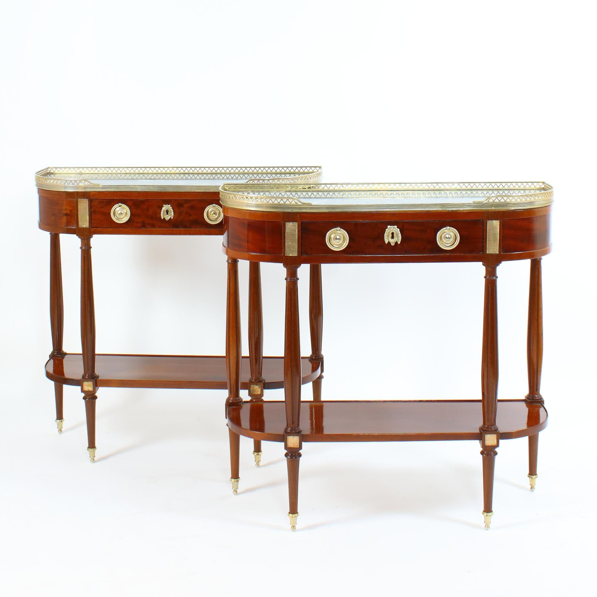 Pair of French Late 19th/Early 20th Century Directoire Style Demilune Console Tables 

Each console table of demilune shape with four feet ending in gilt-bronze sabots which carry the stretcher at the lower part of the console. Four slender fluted