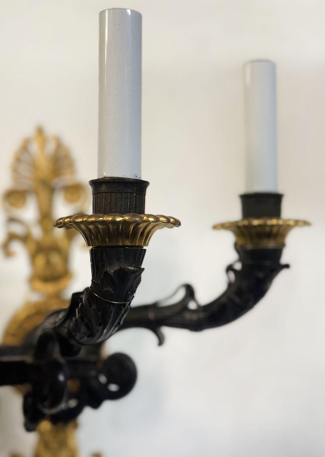 Coppia di appliques in bronzo in stile Impero realizzate in Francia alla fine del XIX secolo. Sono realizzati in bronzo di qualità e con tocchi di bronzo D'ore su tutto il perimetro, tra cui i bobeches, le coppe per le candele e altri dettagli.
Le