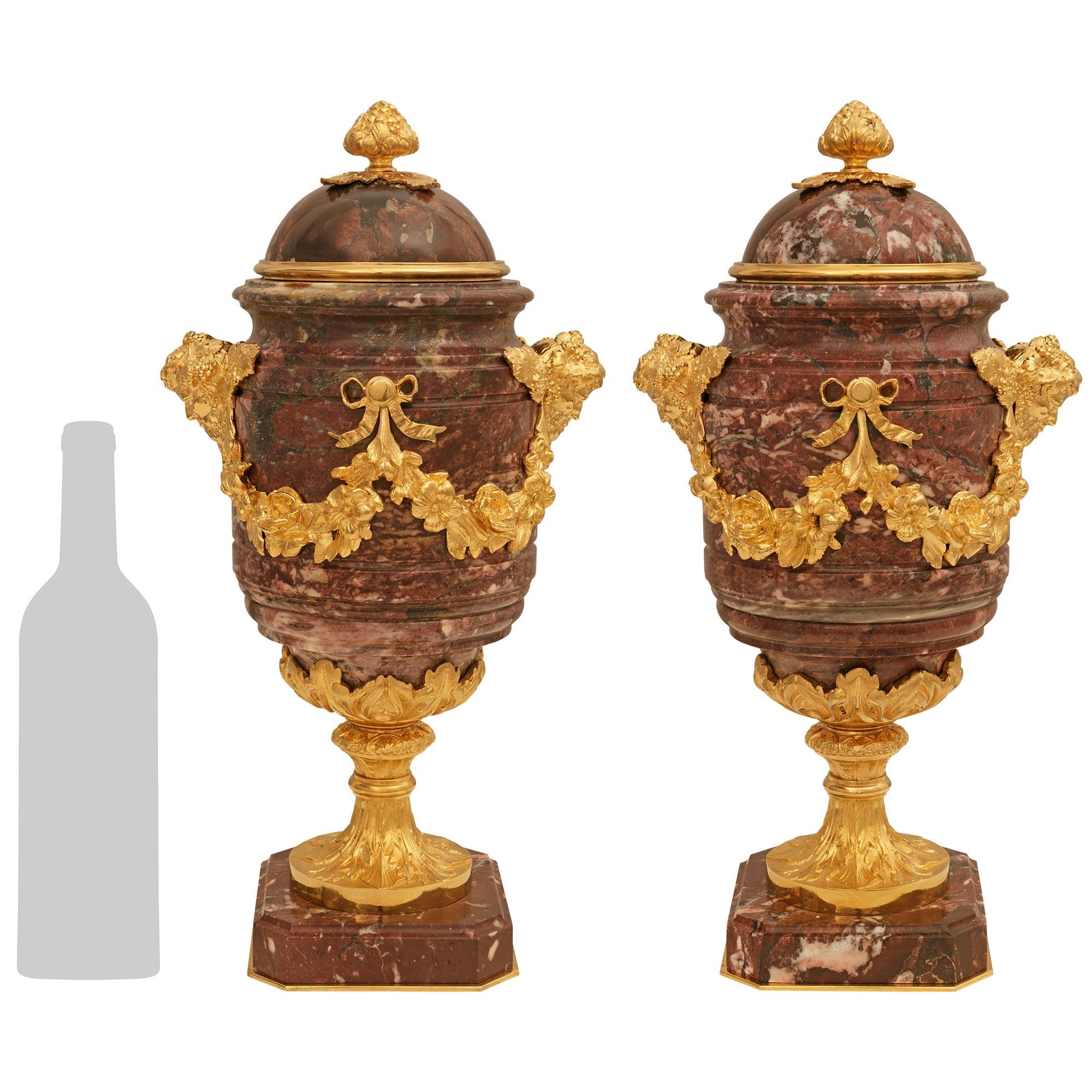 Una coppia deliziosa e di alta qualità di urne francesi della fine del XIX secolo in stile Luigi XVI. Rouge de France e urne con coperchio in Ormolu. Ogni urna, molto decorativa, è sollevata da una base quadrata in marmo Rouge de France ornata di
