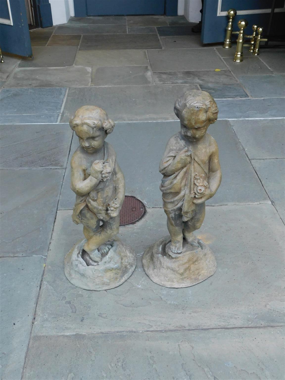 Pair of French lead figural boy and girl foliage garden statues standing on circular molded bases. Early 19th century.