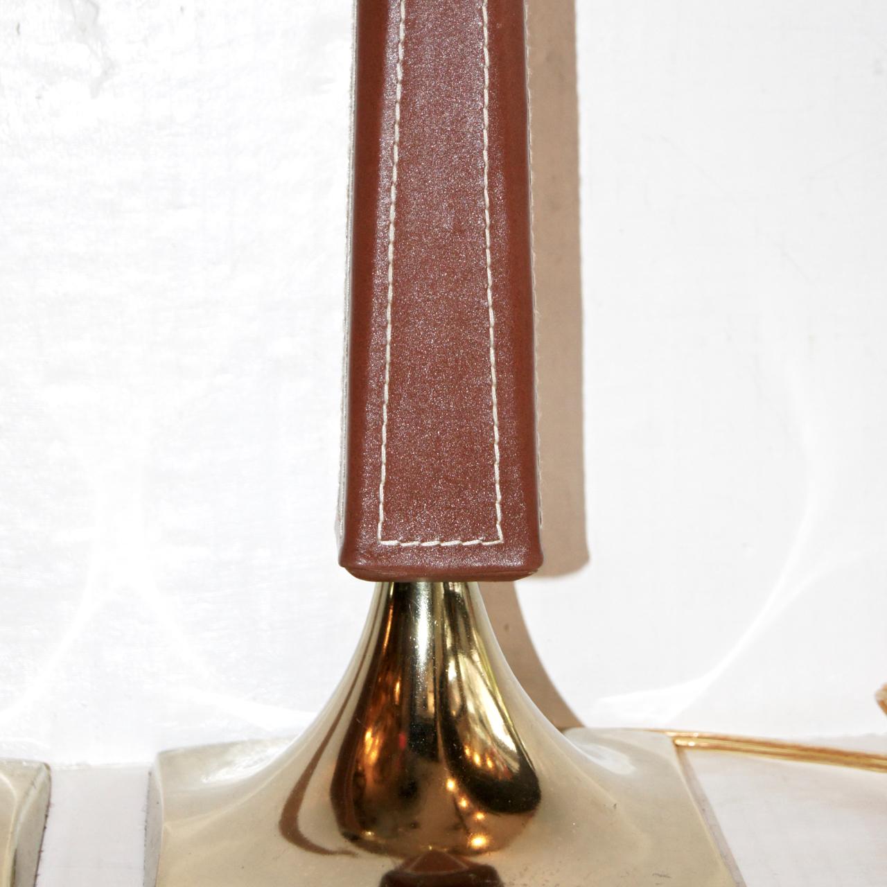 A pair of French circa 1950s stitched leather column table lamps with brass bases.

Measurements:
Height of body: 16