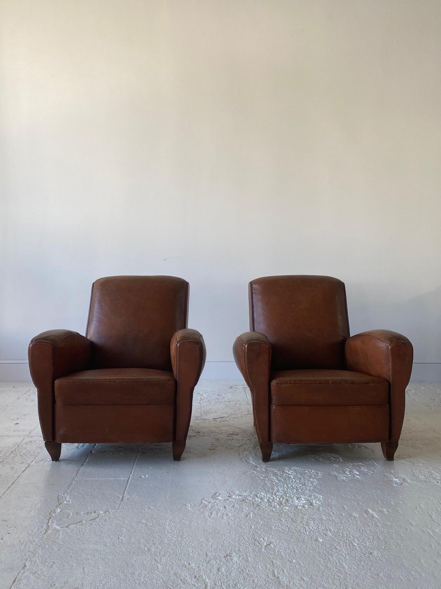 Pair of beautifully aged French leathers club chairs, the chairs offer perfect proportions. The leather offers a beautiful patina.
