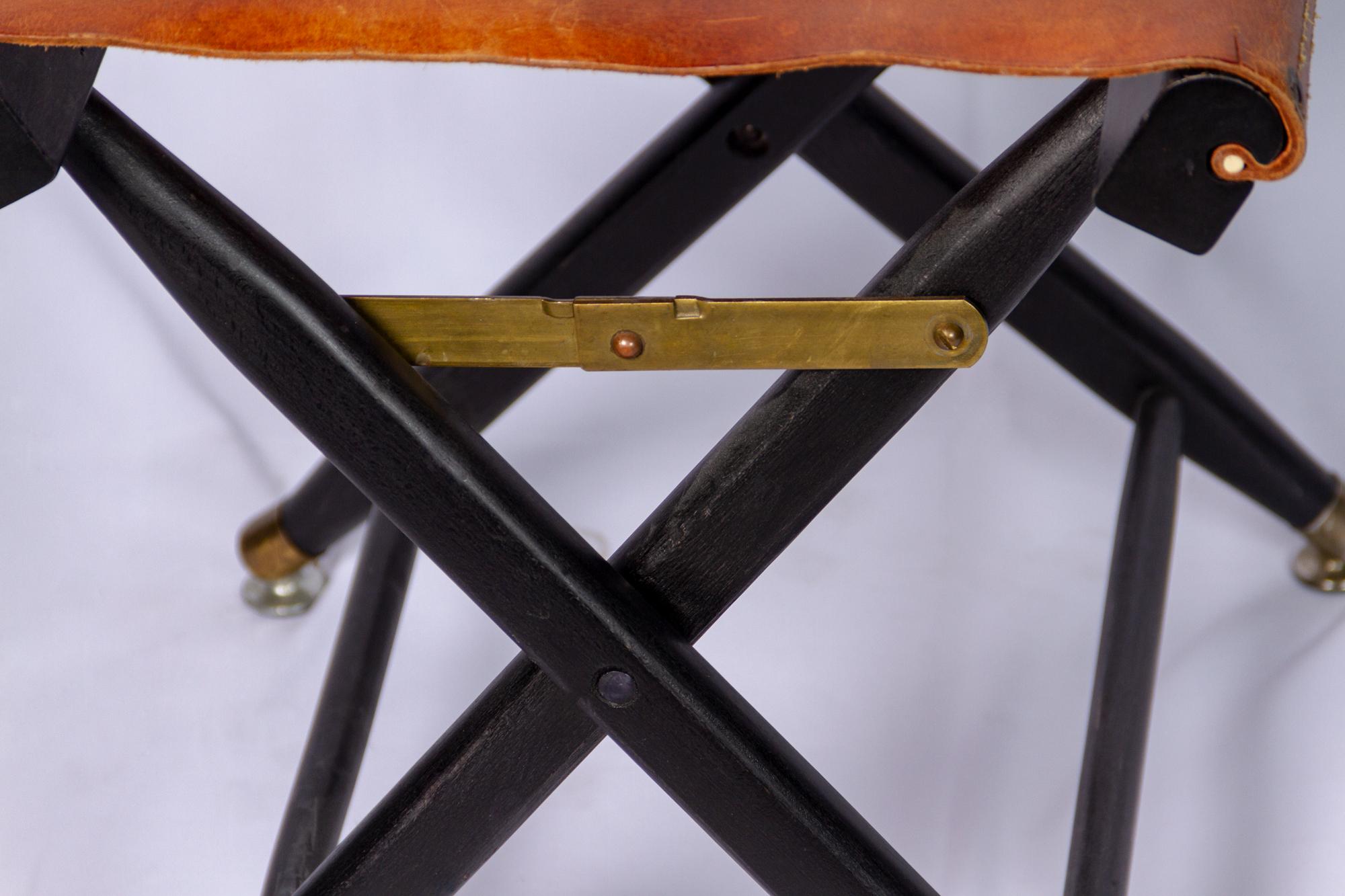 French
A pair of stools, circa 1940.
Of ‘X’ shape, 
the folding leather seats on lacquered wood supports.