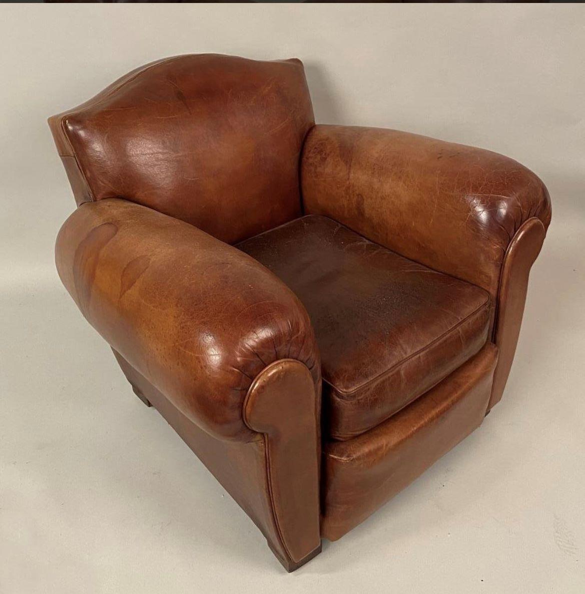 A nice pair of French 1930’s leather “Moustache” club chairs with overstuffed arms and loose seat cushions. Leather is supple with expected wear for the age and use. (See detail photos for imperfections). 