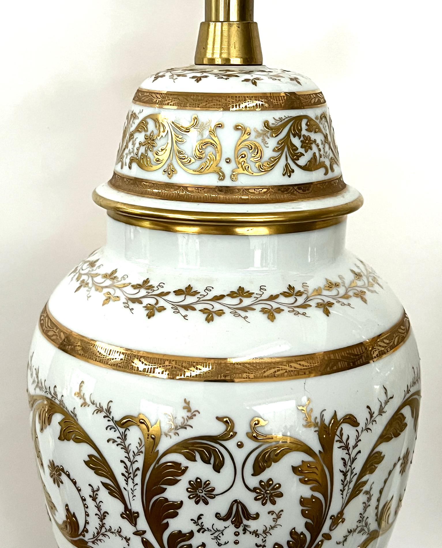 each elegant lamp of ovoid form with domed lid all over a splayed base; adorned overall with applied gilt decoration of meandering foliate vines and scrollwork

The Marbro Lamp Company was established by Morris Markoff and his brother (Mar-bro)