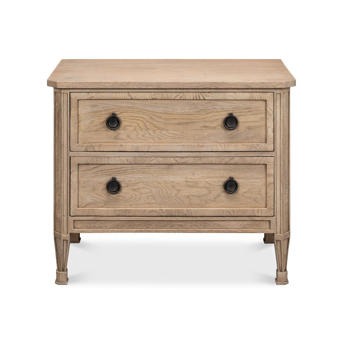 Nightstand draws inspiration from 18th-century French design with its elegant proportions and flaky pine finish over oak. The classical form features meticulously crafted details including inset drawer panels, authentic ring pulls, and tapered legs